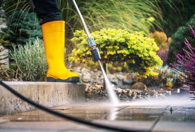 Pressure washing professional inspecting clean walkway at a residential home in Muhlenberg County Kentucky