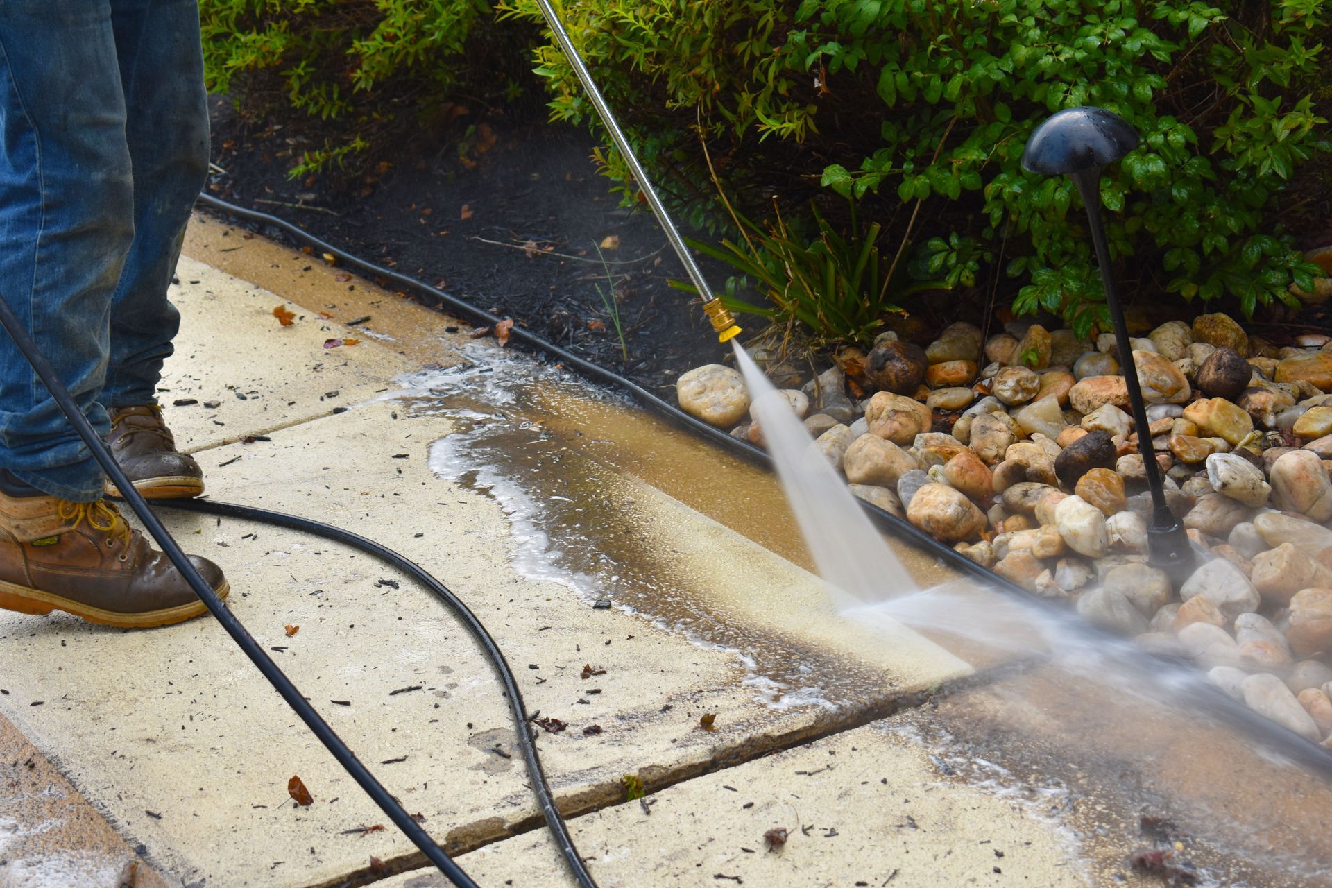 Exterior surface cleaning technician washing vinyl siding on a residential home in Muhlenberg County KY