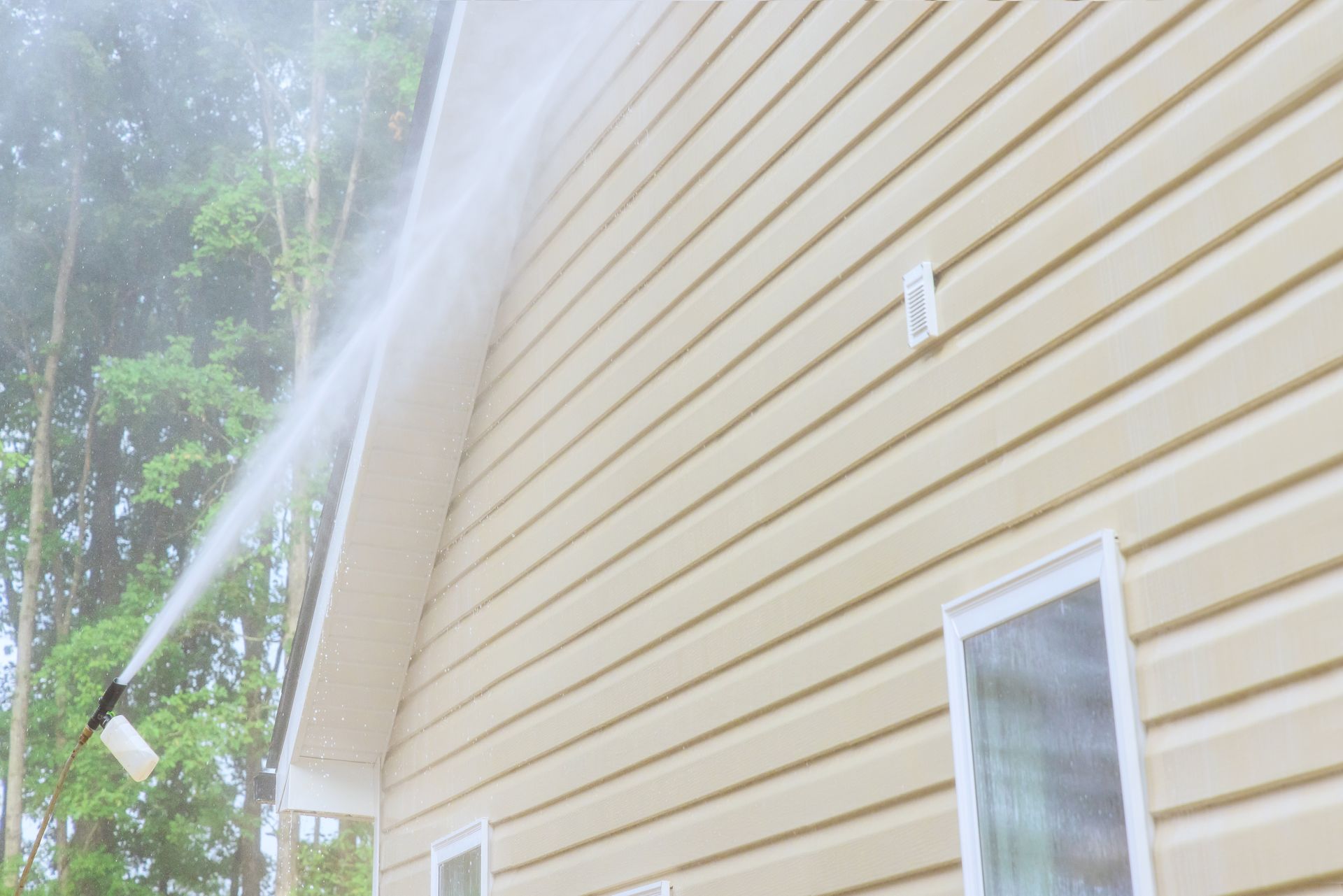 Exterior surface cleaning technician washing vinyl siding on a residential home in Muhlenberg County KY