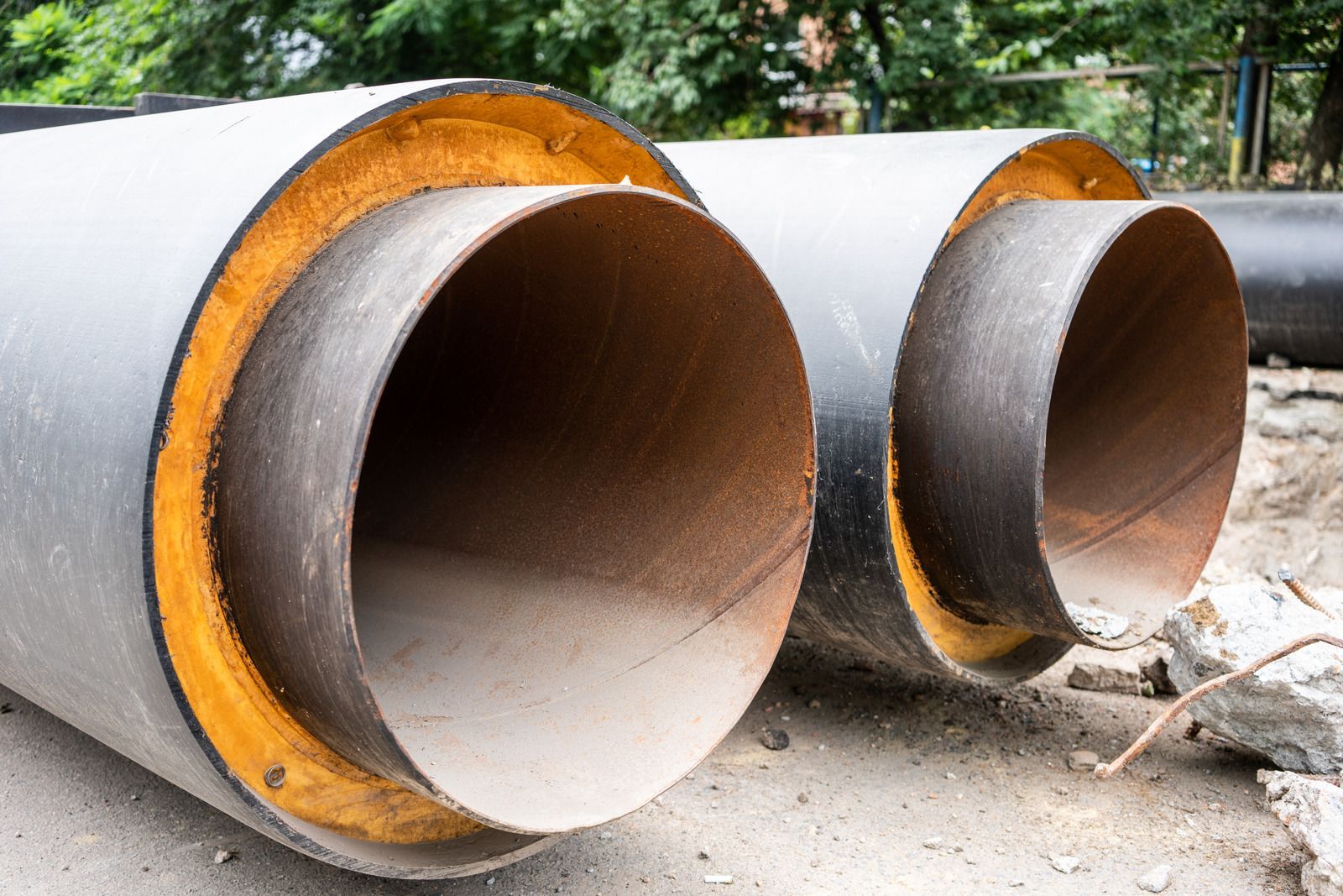 Two pipes are sitting next to each other on the ground.