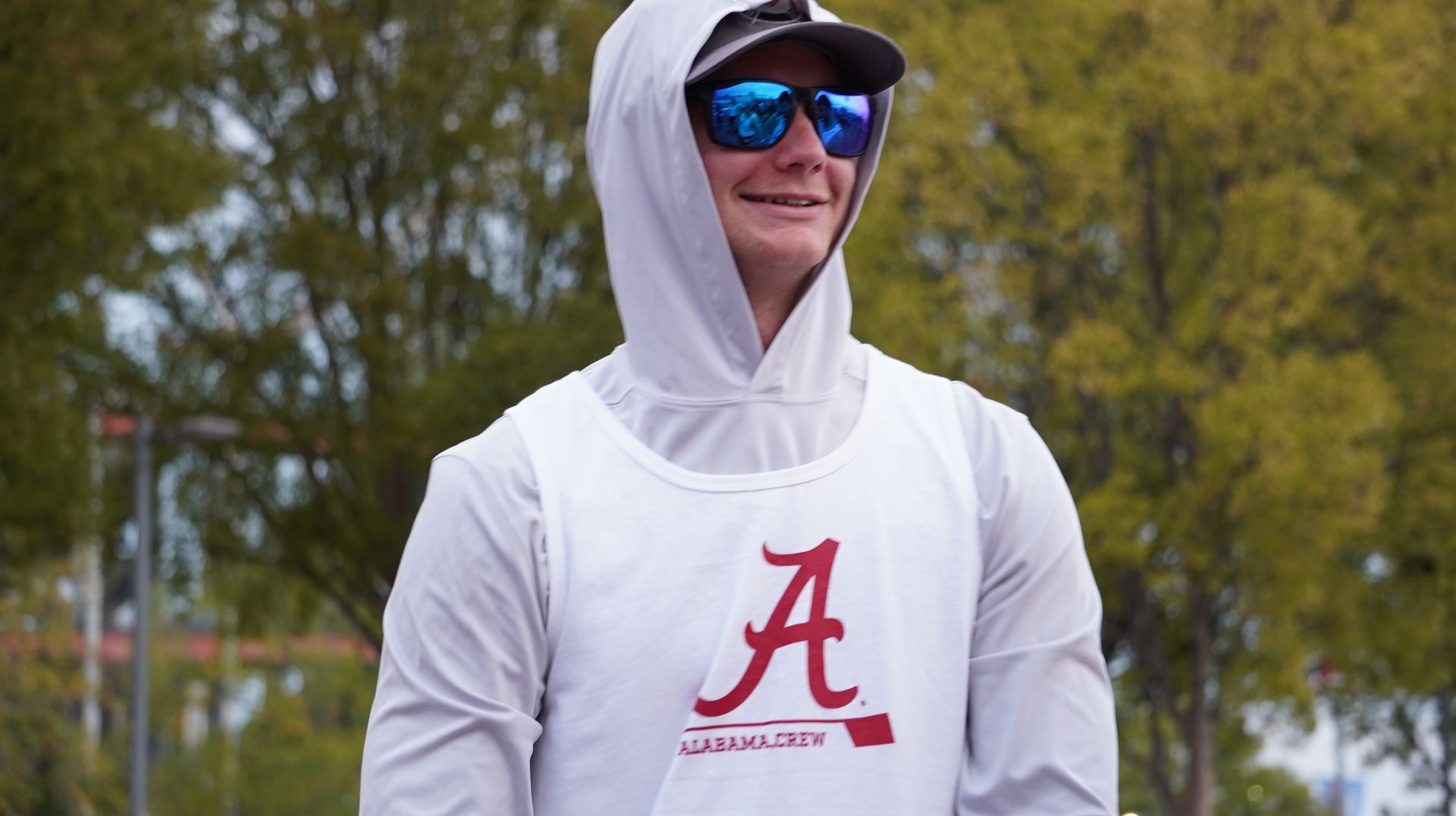 A young man in sunglasses and a hooded shirt with the Alabama Crimson Tide 