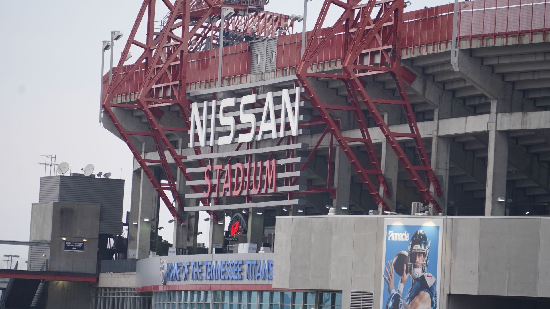 Nissan Stadium exterior with the name in large white letters; red and gray structure.