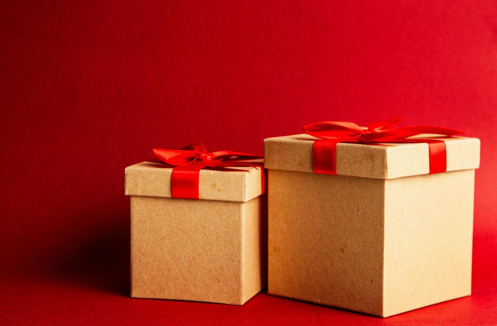 Holiday gift boxes with custom packaging and red ribbons for seasonal kitting services