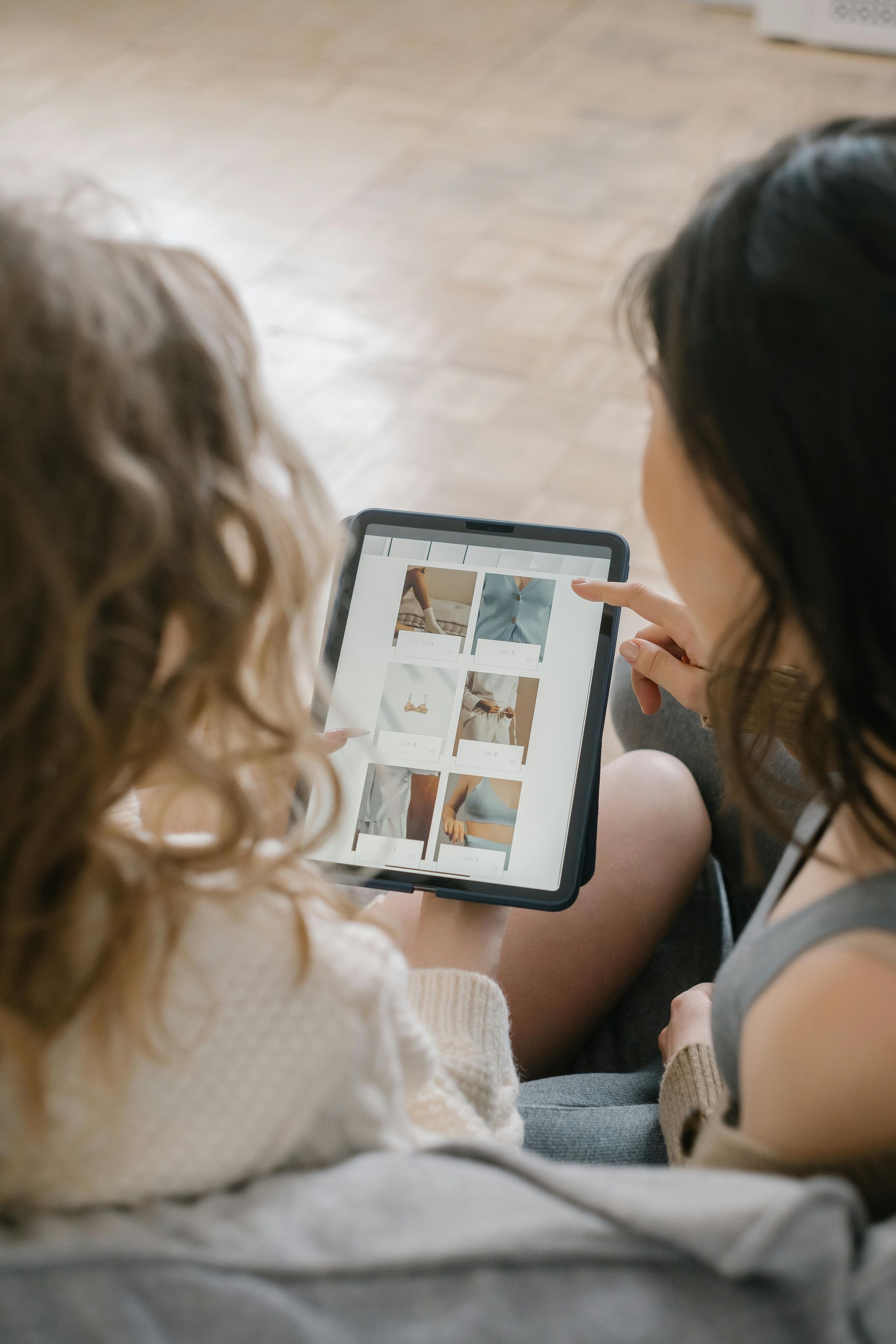 Women shopping online on tablet reviewing product options