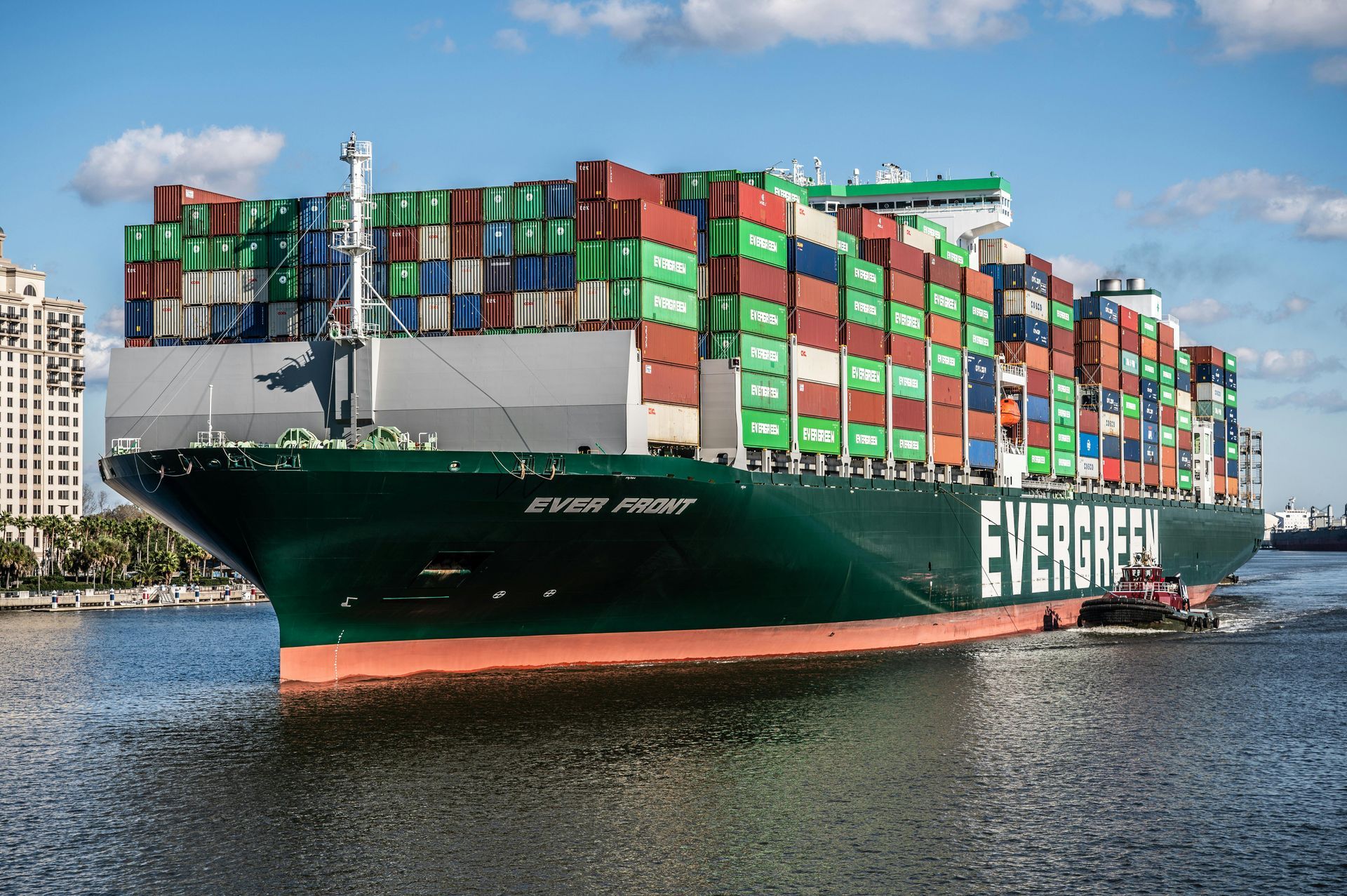 Cargo vessel loaded with consolidated freight containers reducing shipping costs