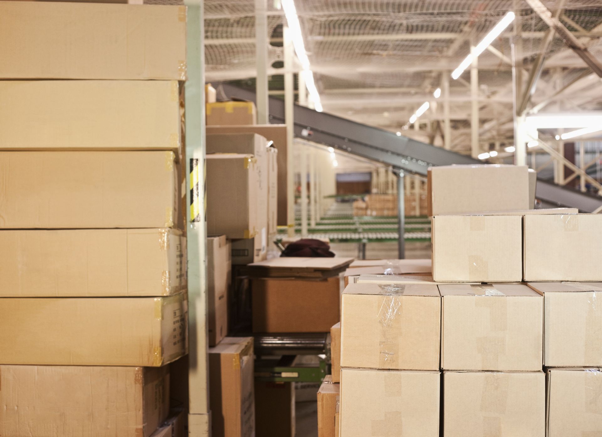 A warehouse filled with lots of cardboard boxes stacked on top of each other.