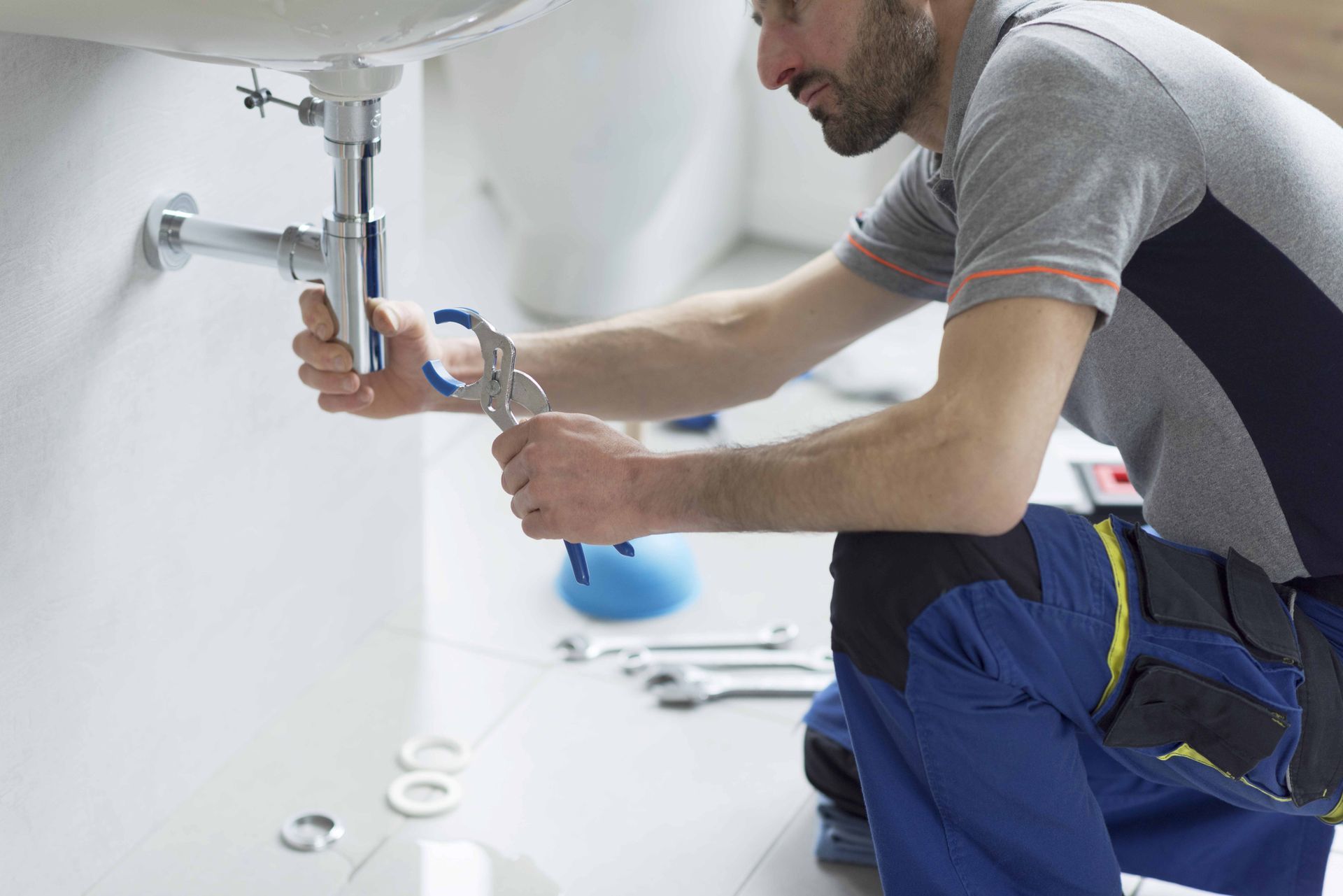 Professional plumber checking a sink drain. Professional plumber checking a sink drain.