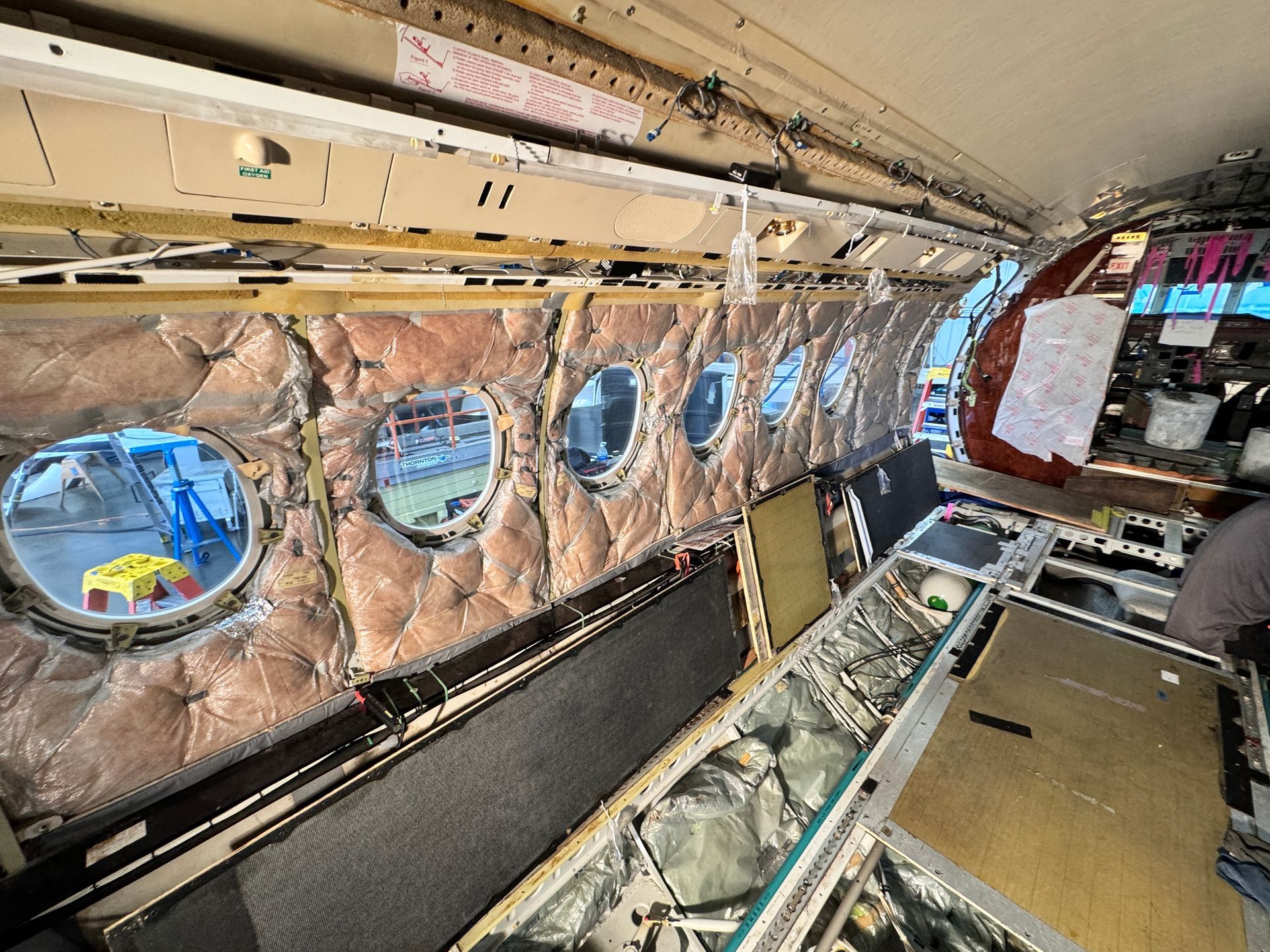 A man is working on the inside of an airplane.