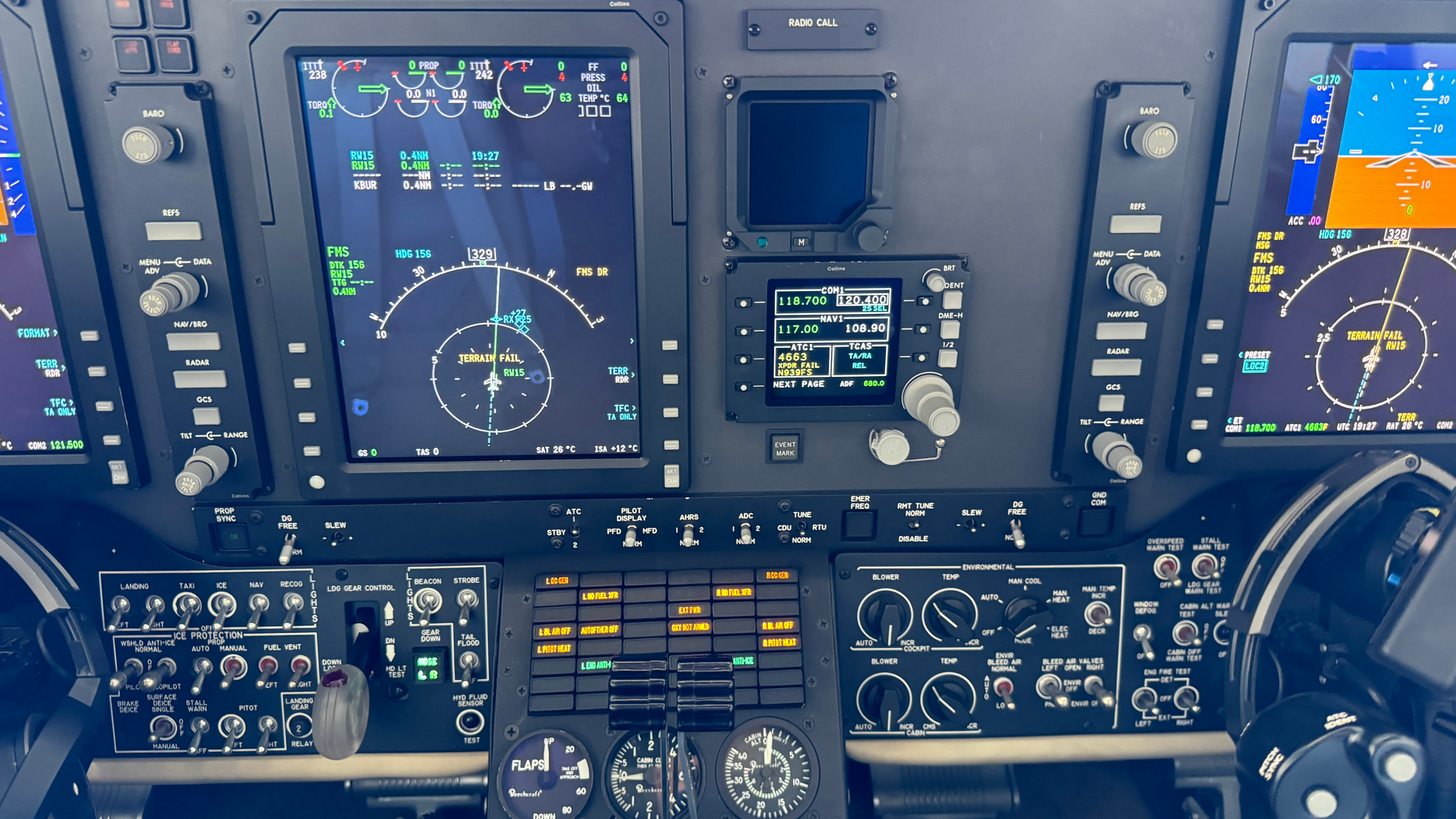 A cockpit of an airplane with many monitors and buttons