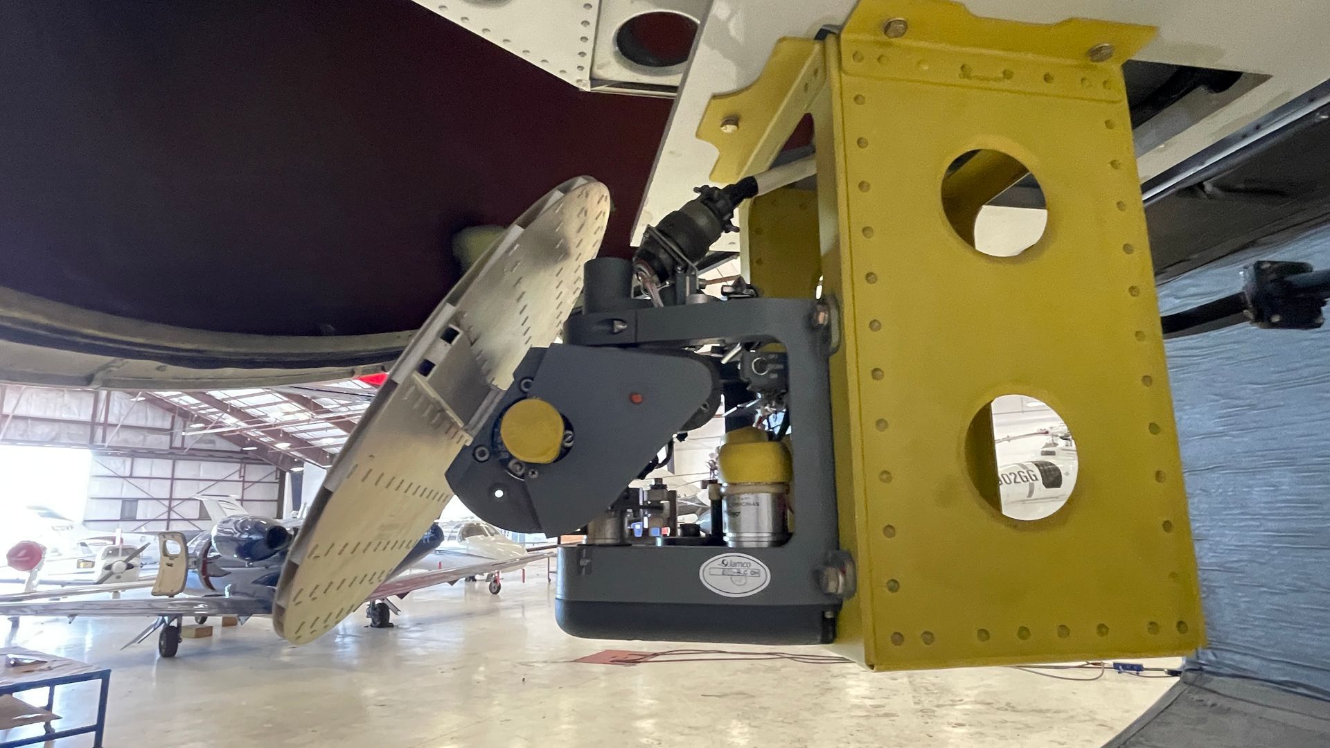 A plane is sitting in a hangar with a yellow bracket attached to it