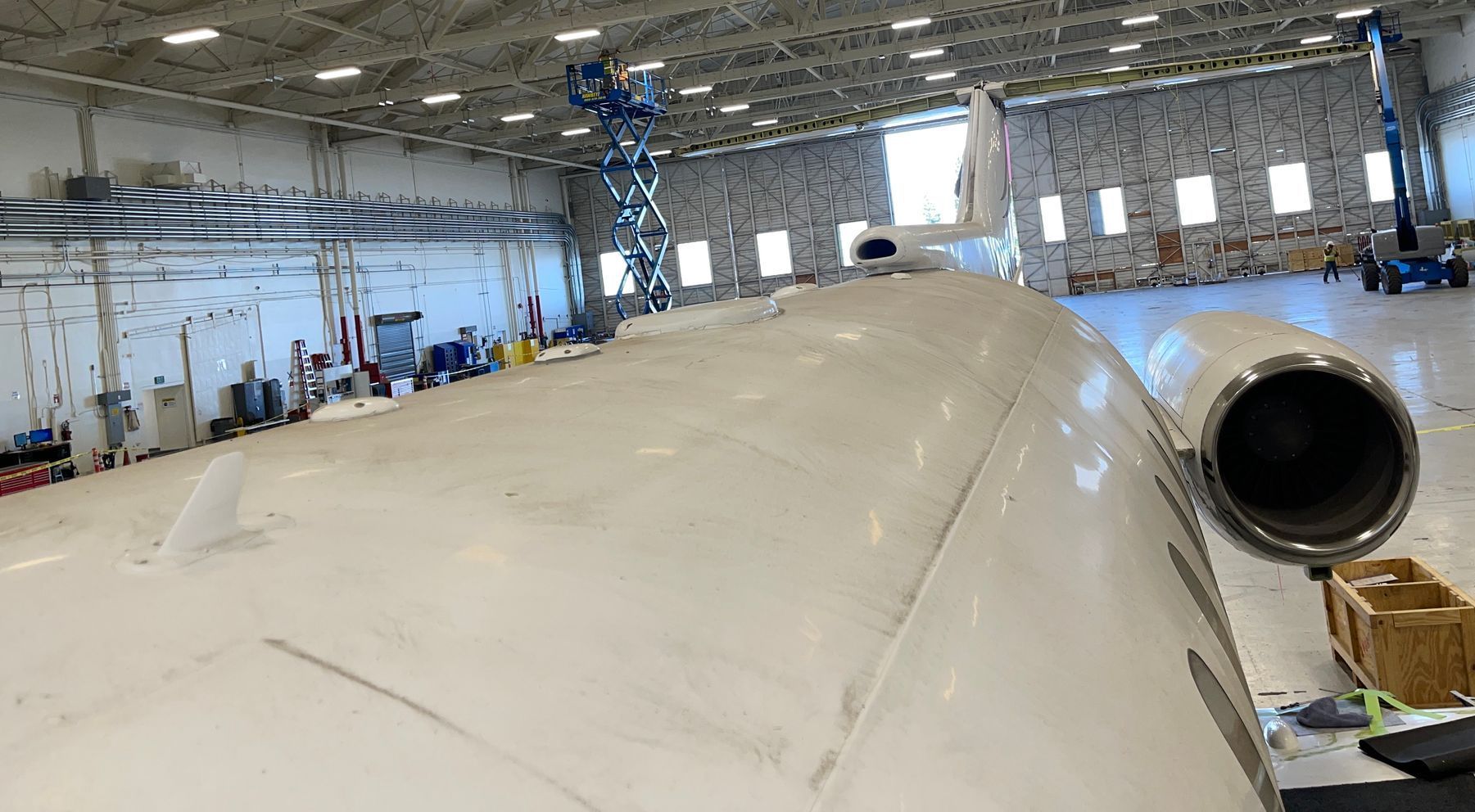 A plane is being repaired in a hangar.
