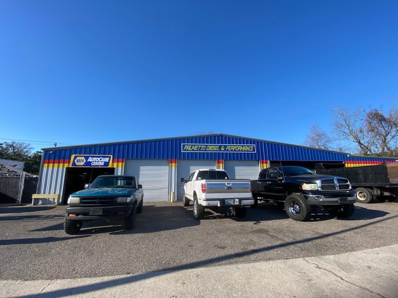 three trucks are parked in front of a garage .