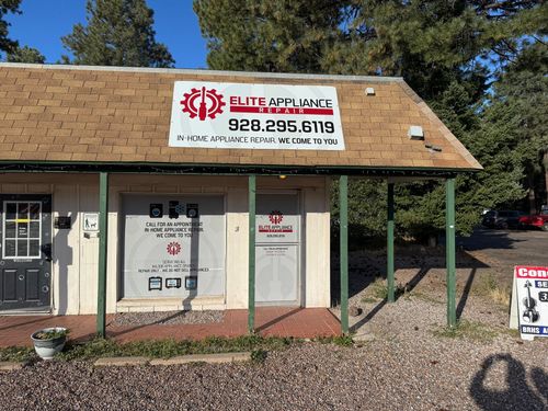 A white building with a sign that says ' elite appliance ' on it.