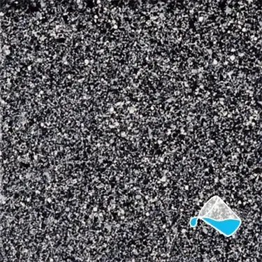A close up of a black and white surface with a measuring cup filled with water.
