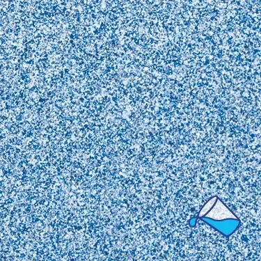A bucket of water is being poured on a blue surface.