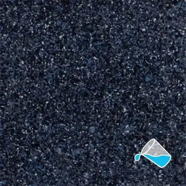 A close up of a black surface with a measuring cup pouring water on it.