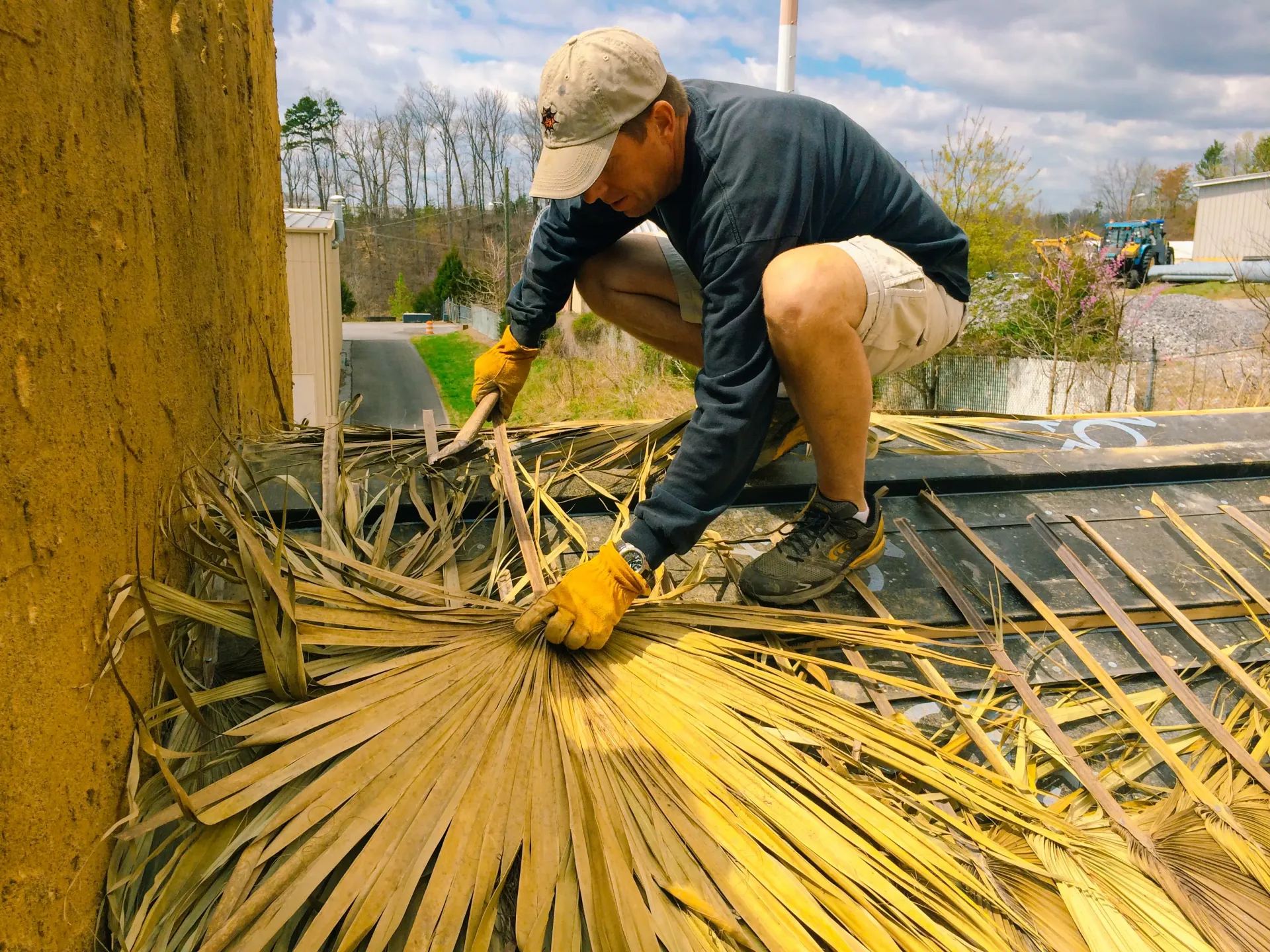 A man is working on a roof with a shovel.