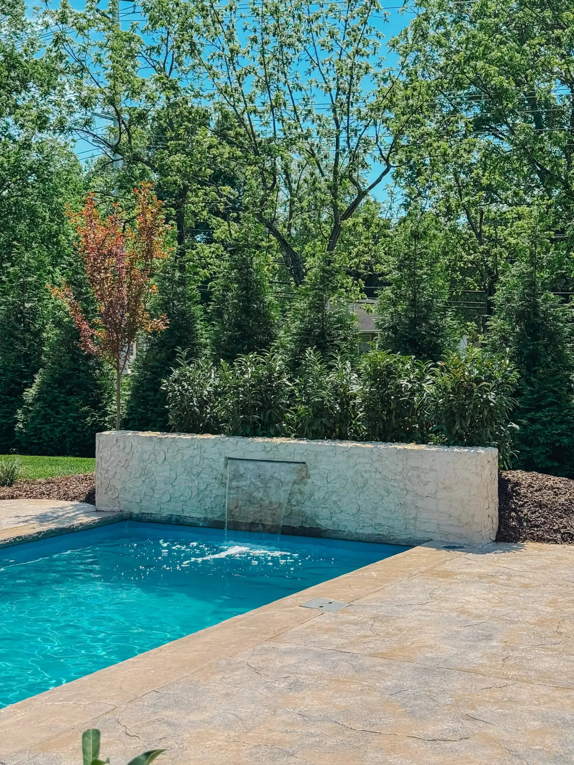 There is a waterfall in the middle of the pool.