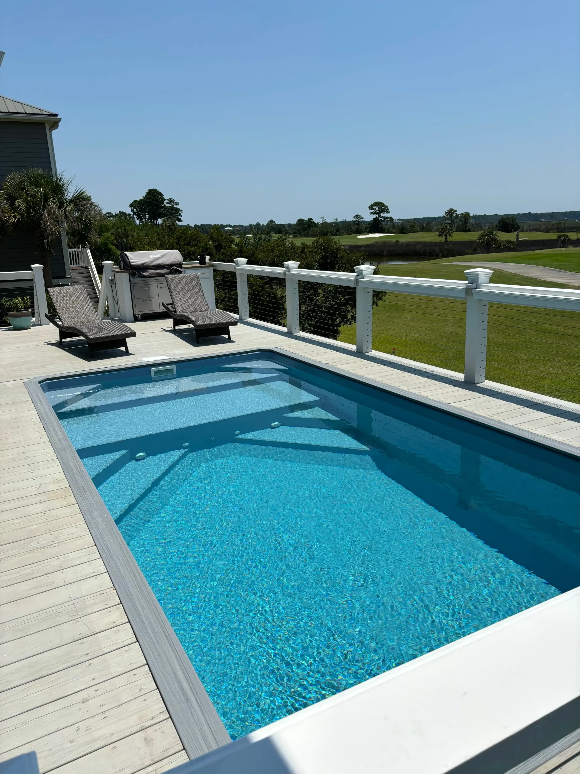 A large swimming pool with a white fence around it