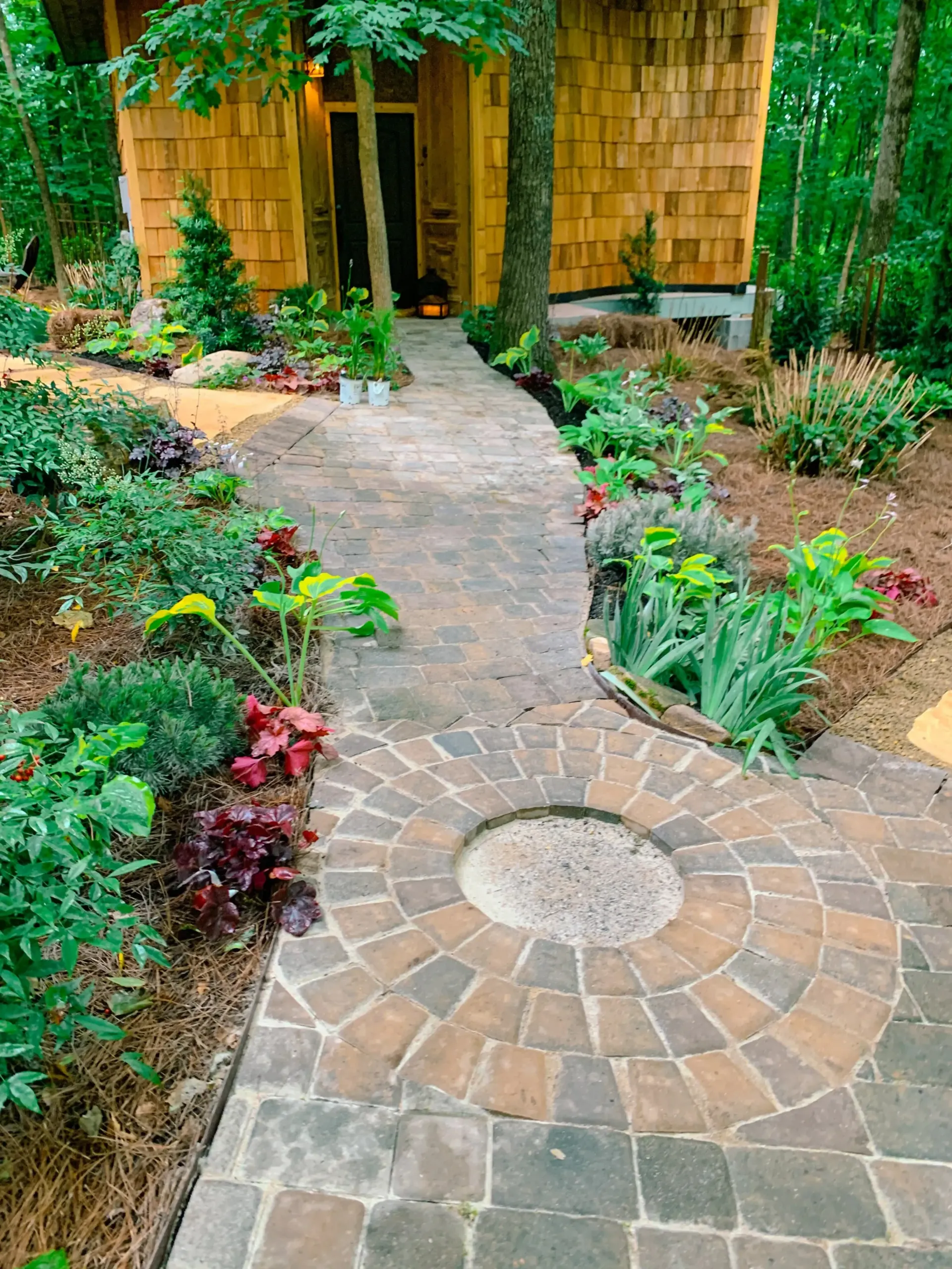 Custom brick garden walkway surrounded by native landscaping and vibrant perennials, 