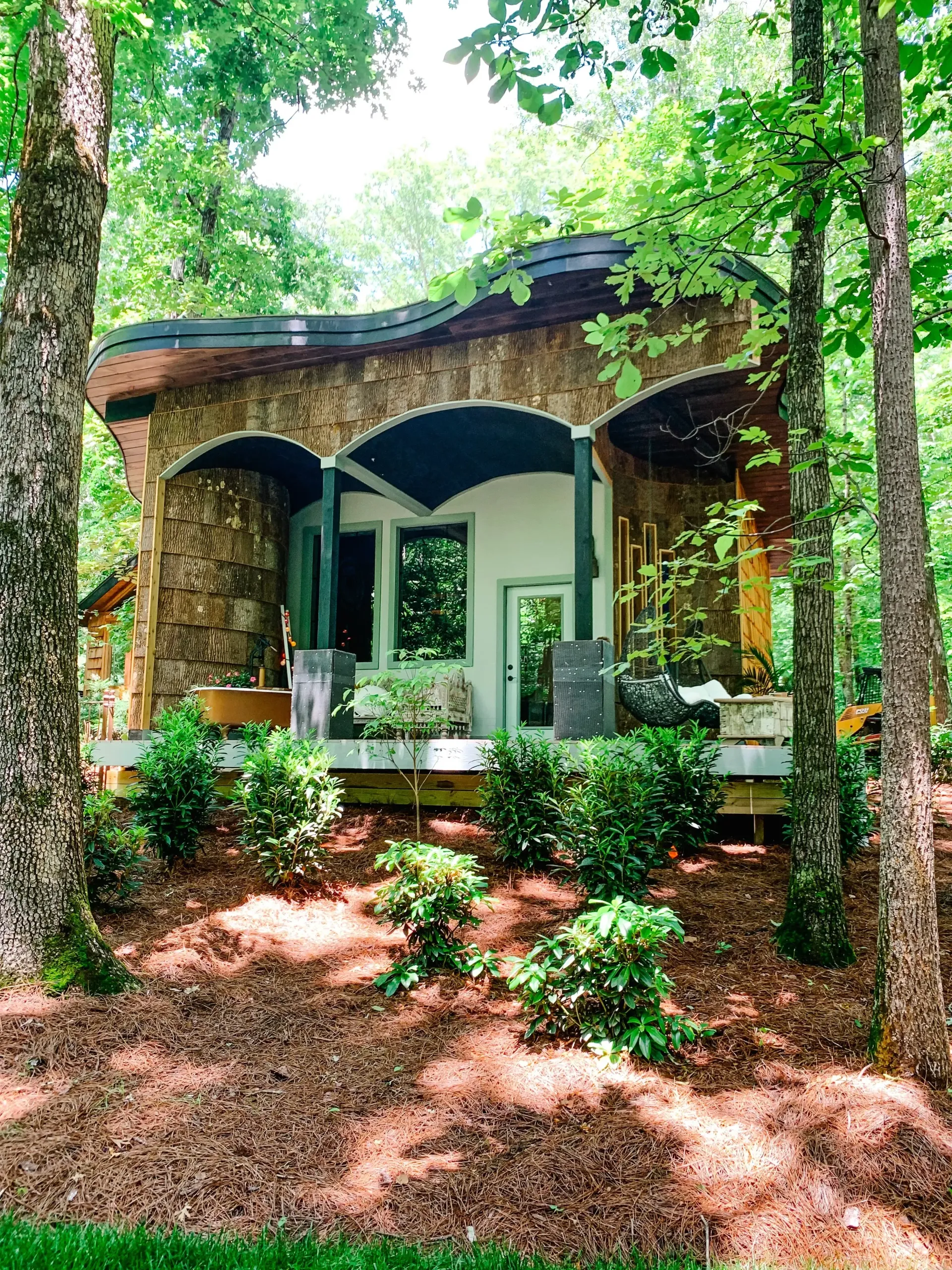 A small house in the middle of a forest surrounded by trees.