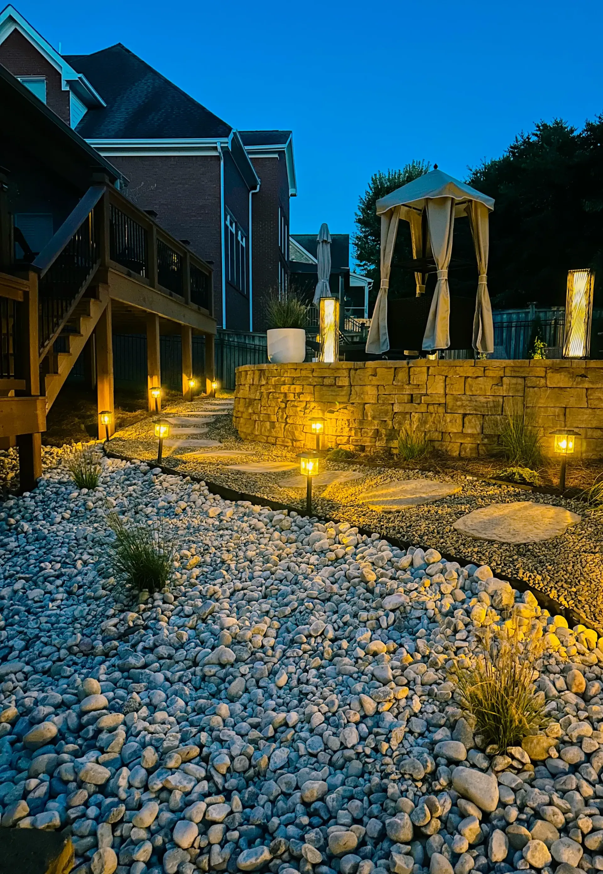 A house with a gazebo in the backyard at night.