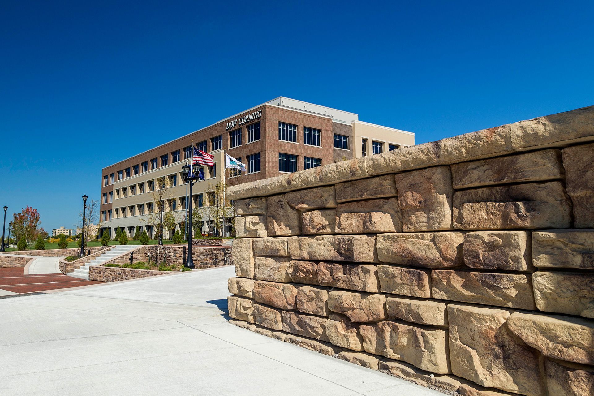 A large building with a stone wall in front of it.