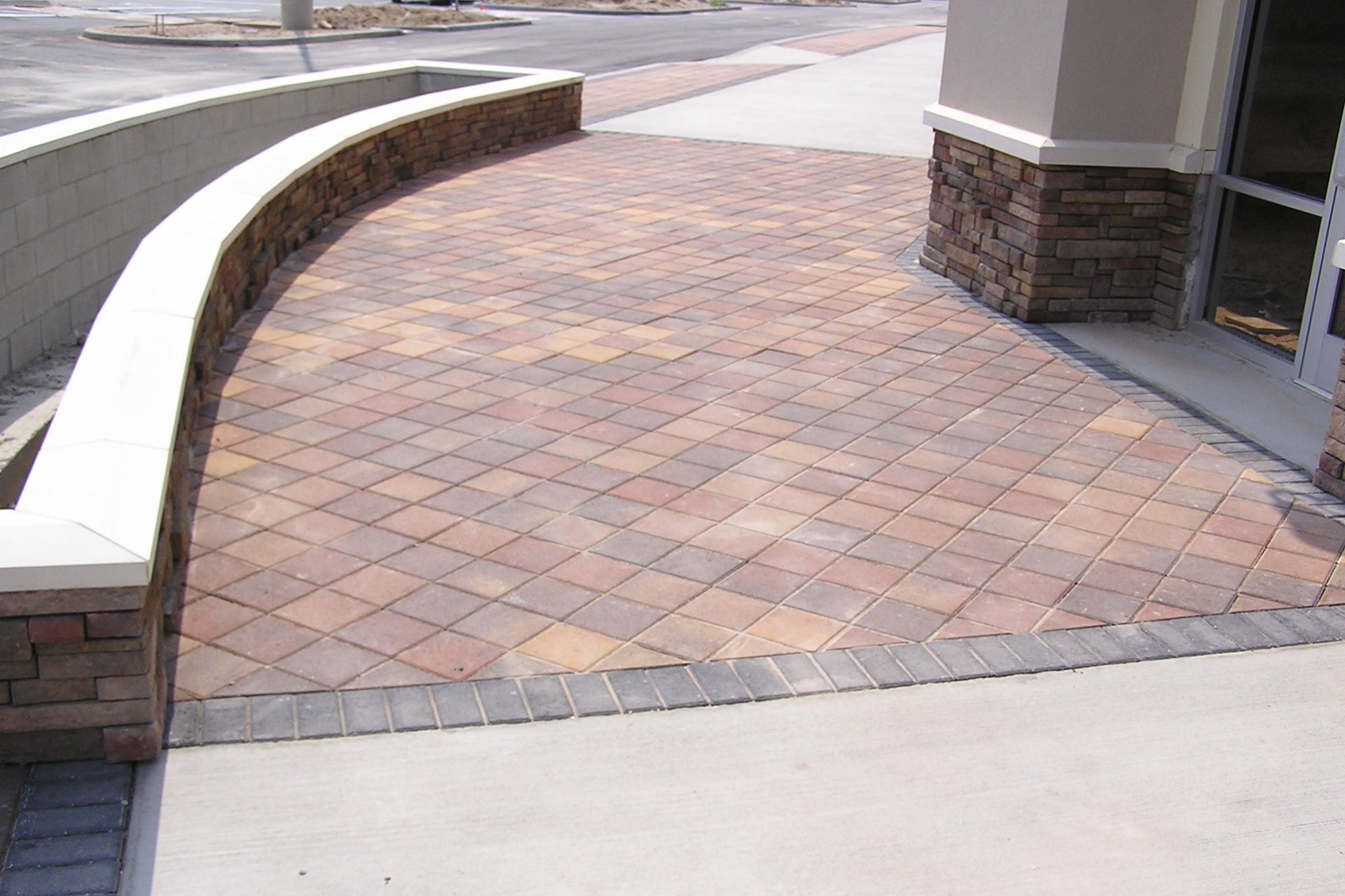 A brick walkway leading to a building with a brick wall