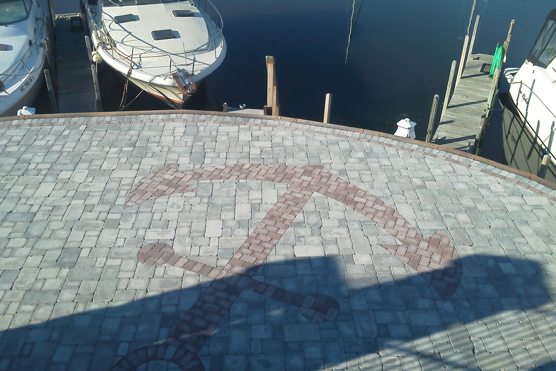 A boat is docked in a harbor with a brick walkway leading to it