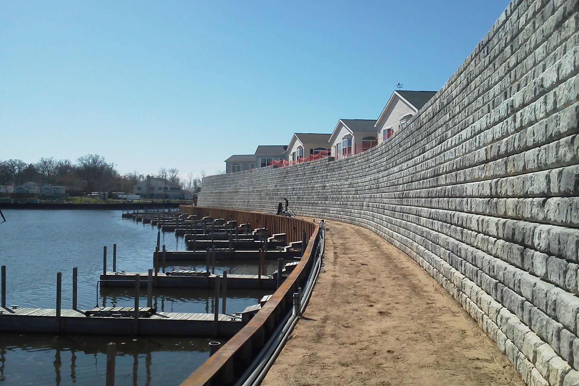 A large brick wall surrounds a body of water