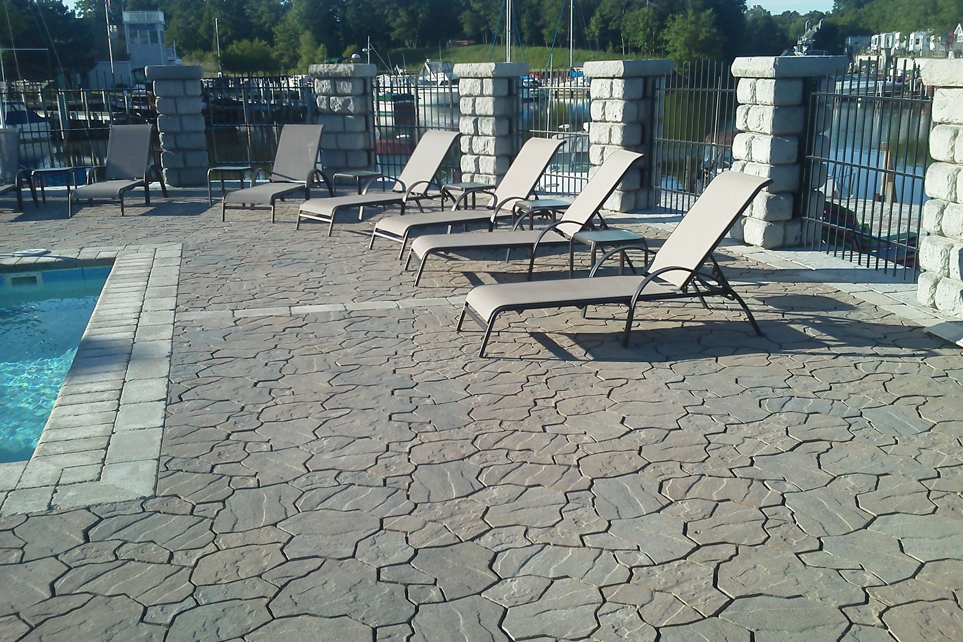 A row of lounge chairs next to a swimming pool