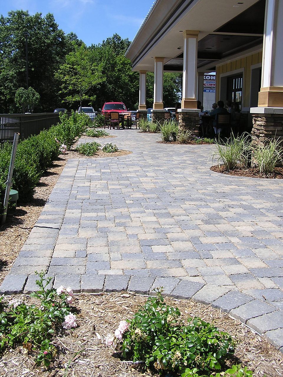 A brick walkway leading to a large building