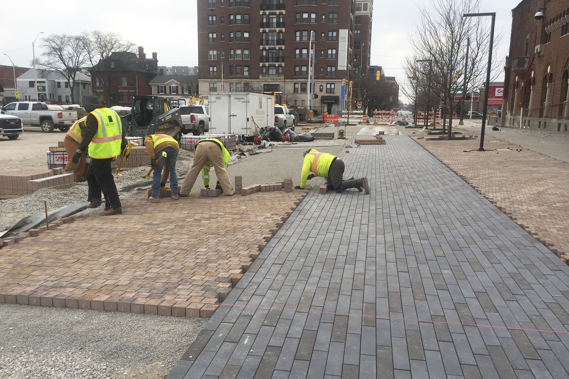 A group of construction workers are working on a sidewalk