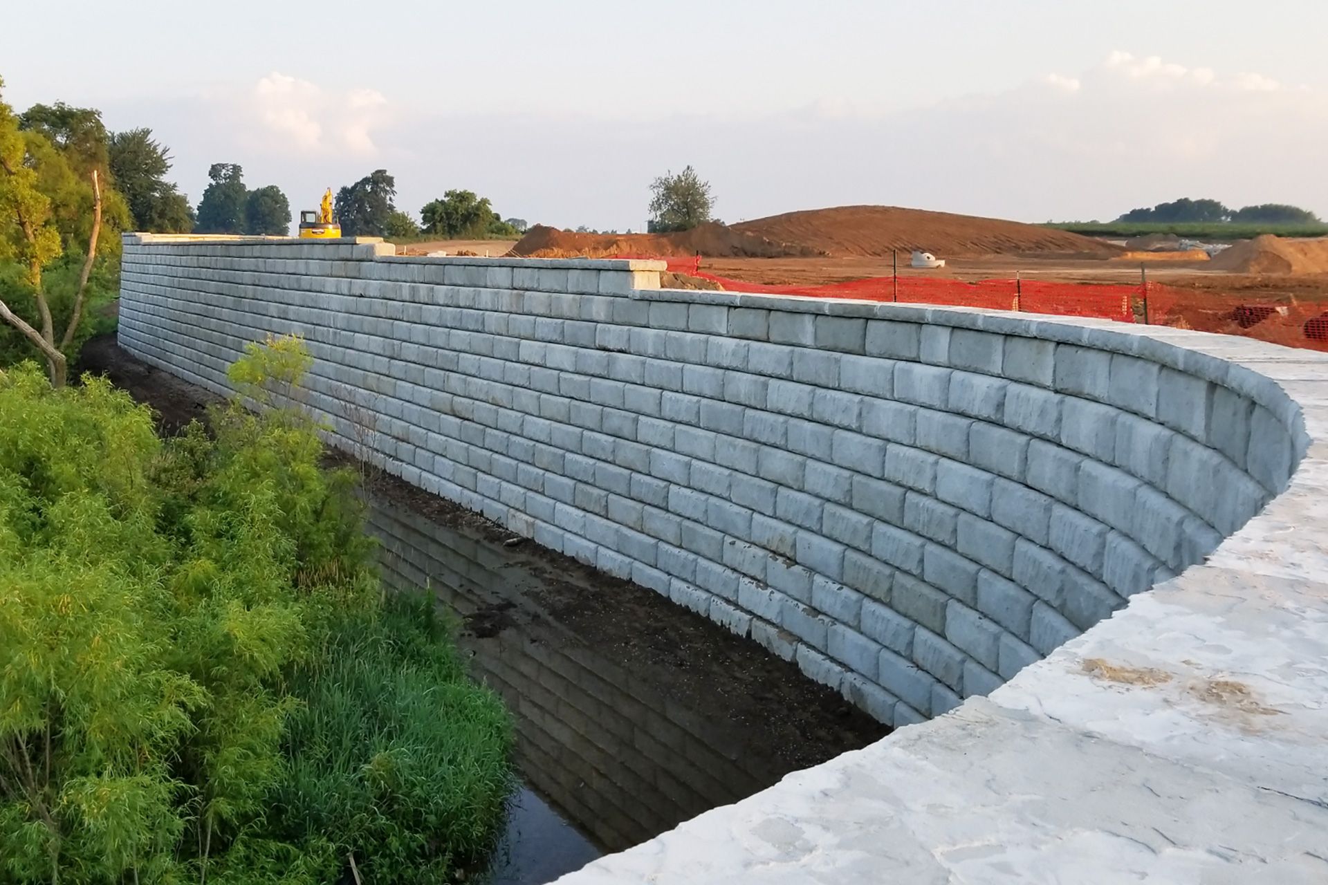 A large brick wall is being built over a river.