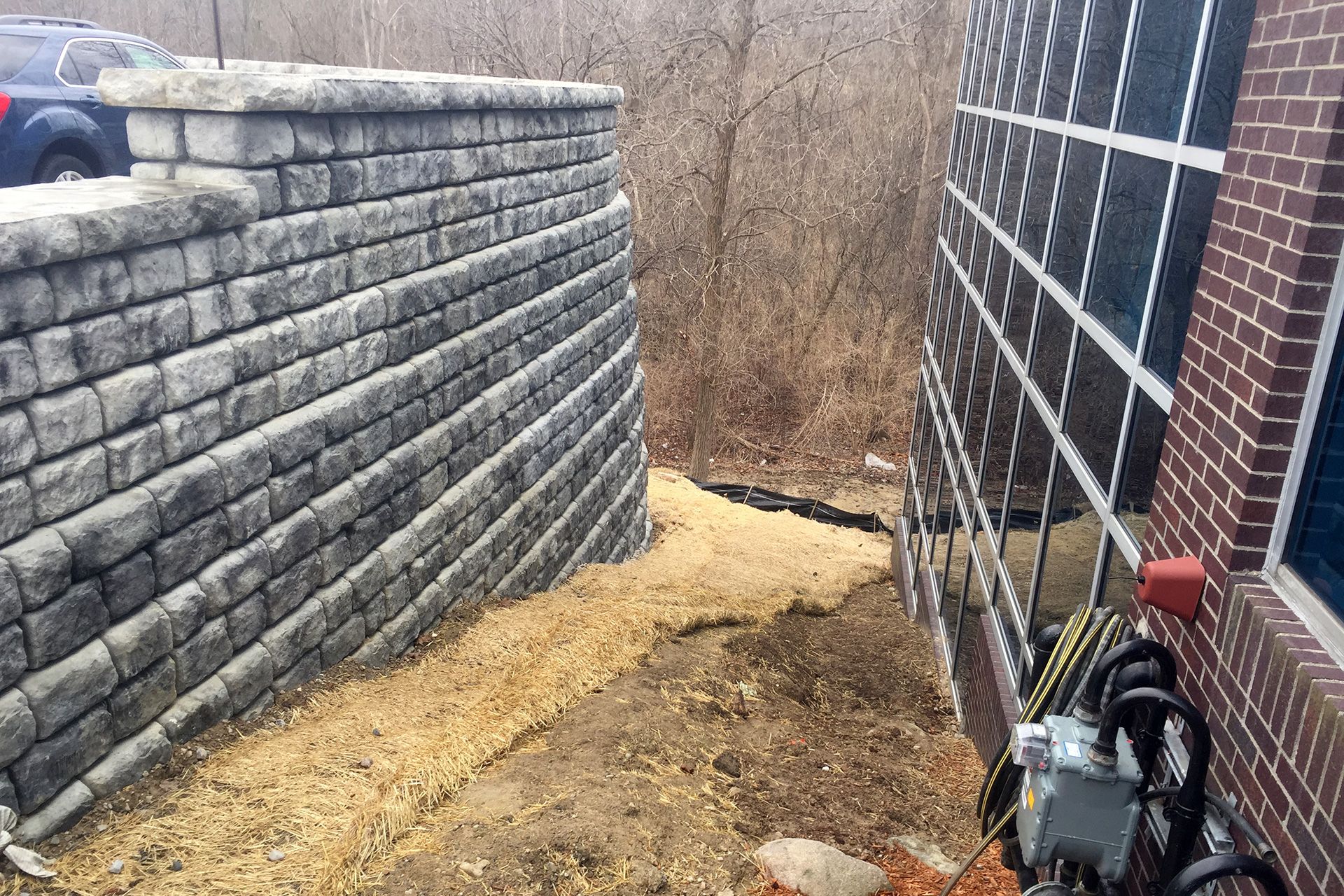 A brick wall is next to a brick building.