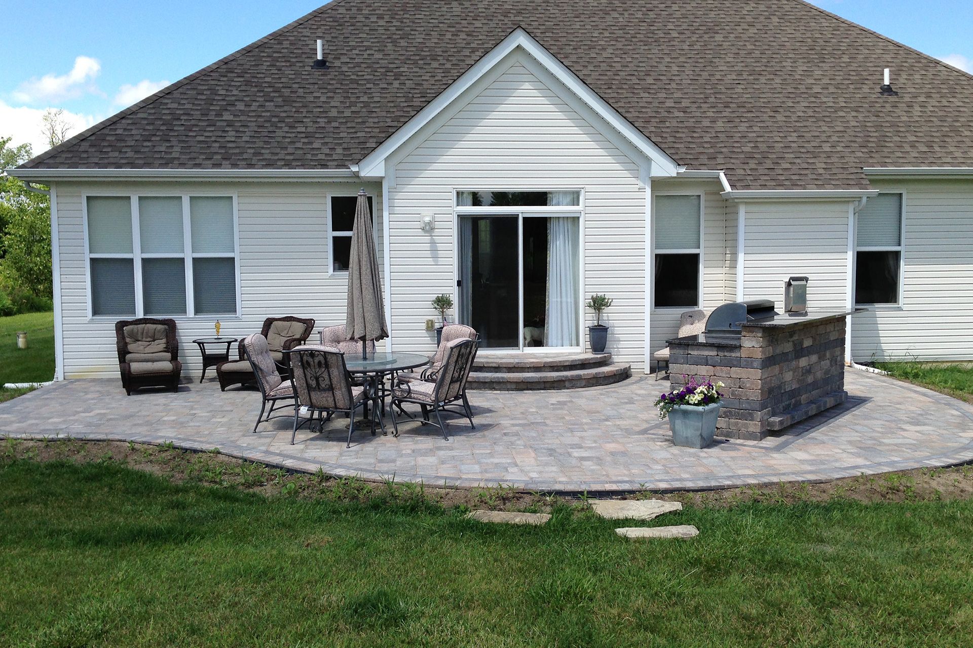 A white house with a patio in front of it.