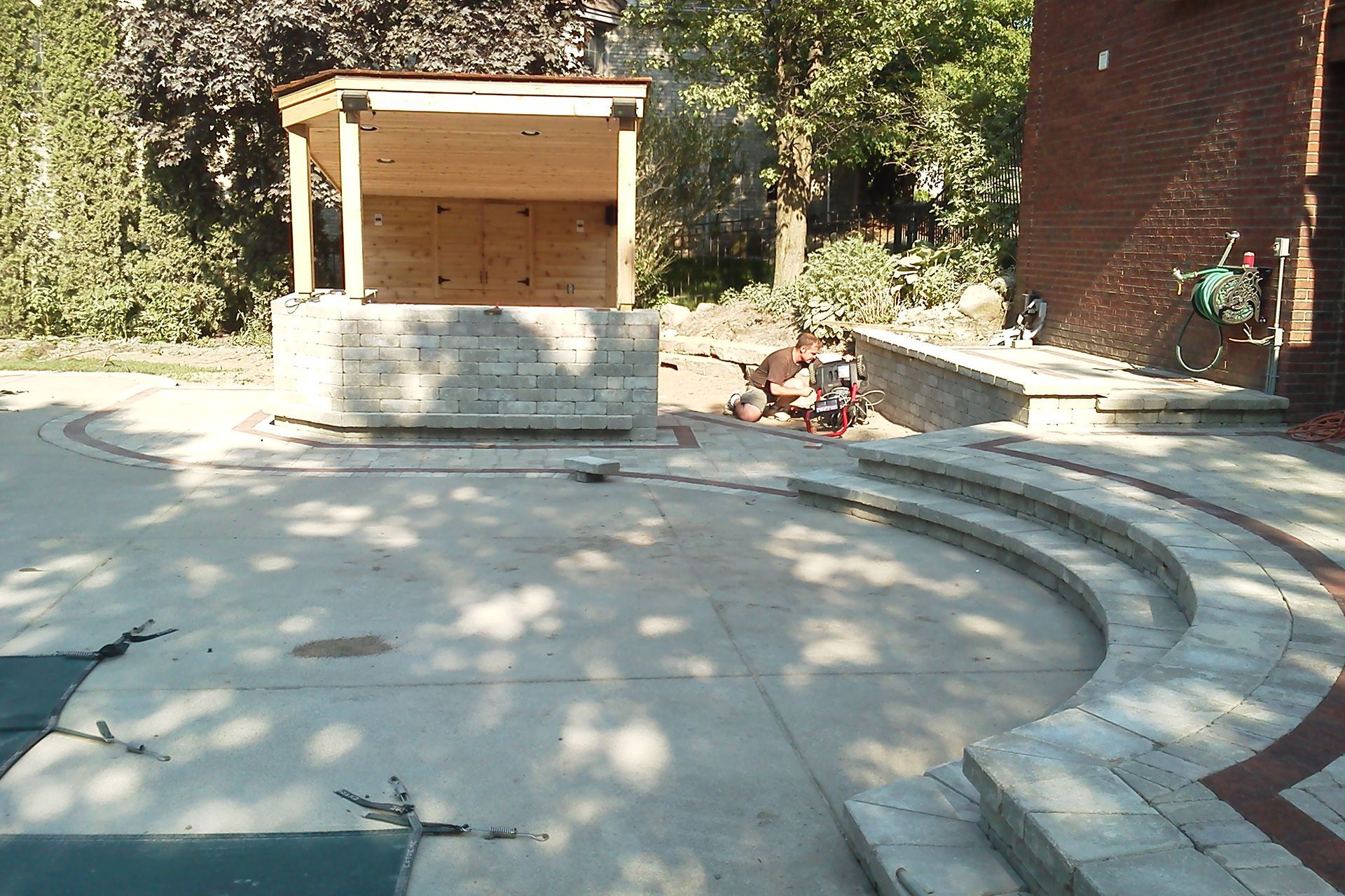A concrete patio with steps and a wooden structure in the background
