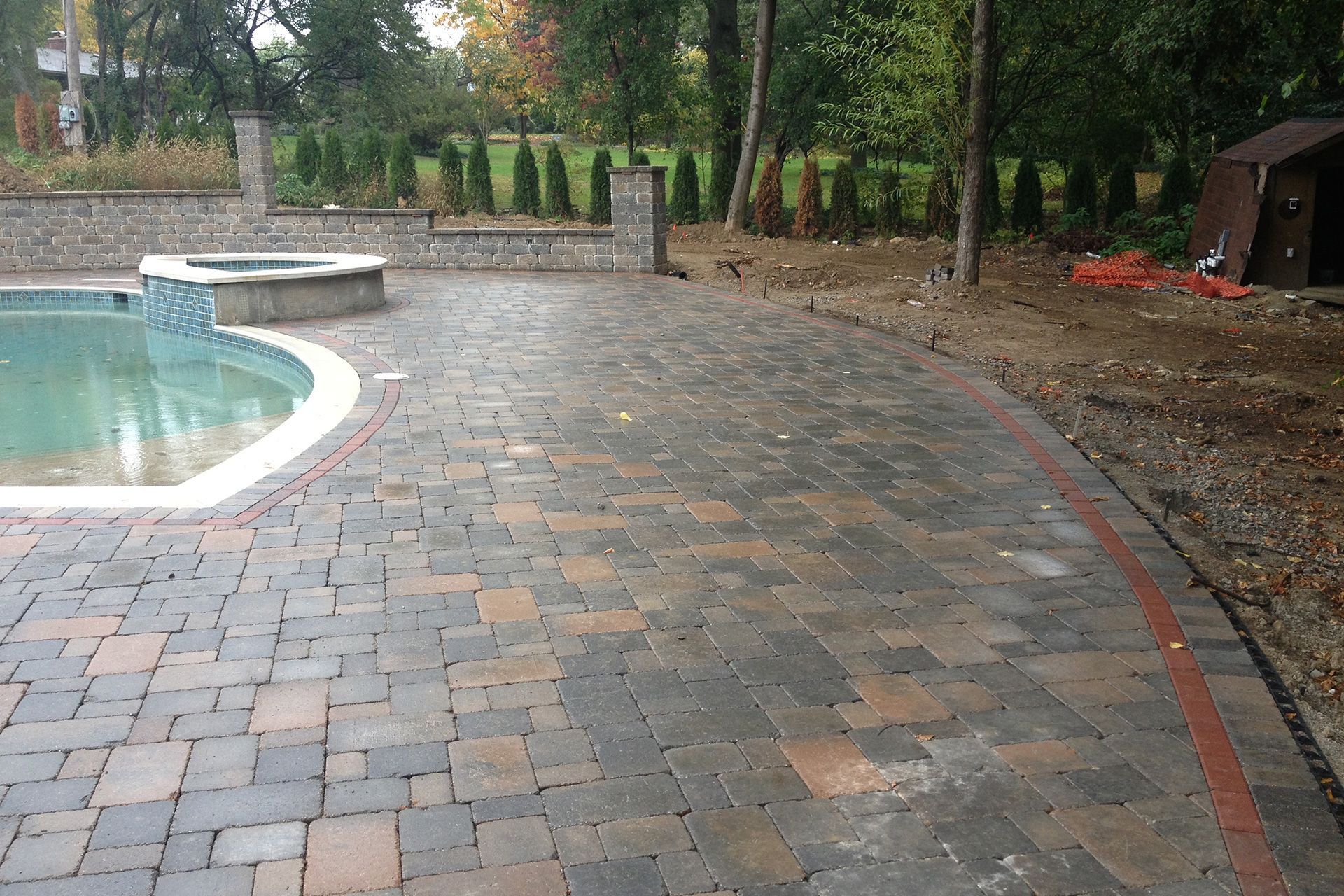 A patio with a swimming pool in the background