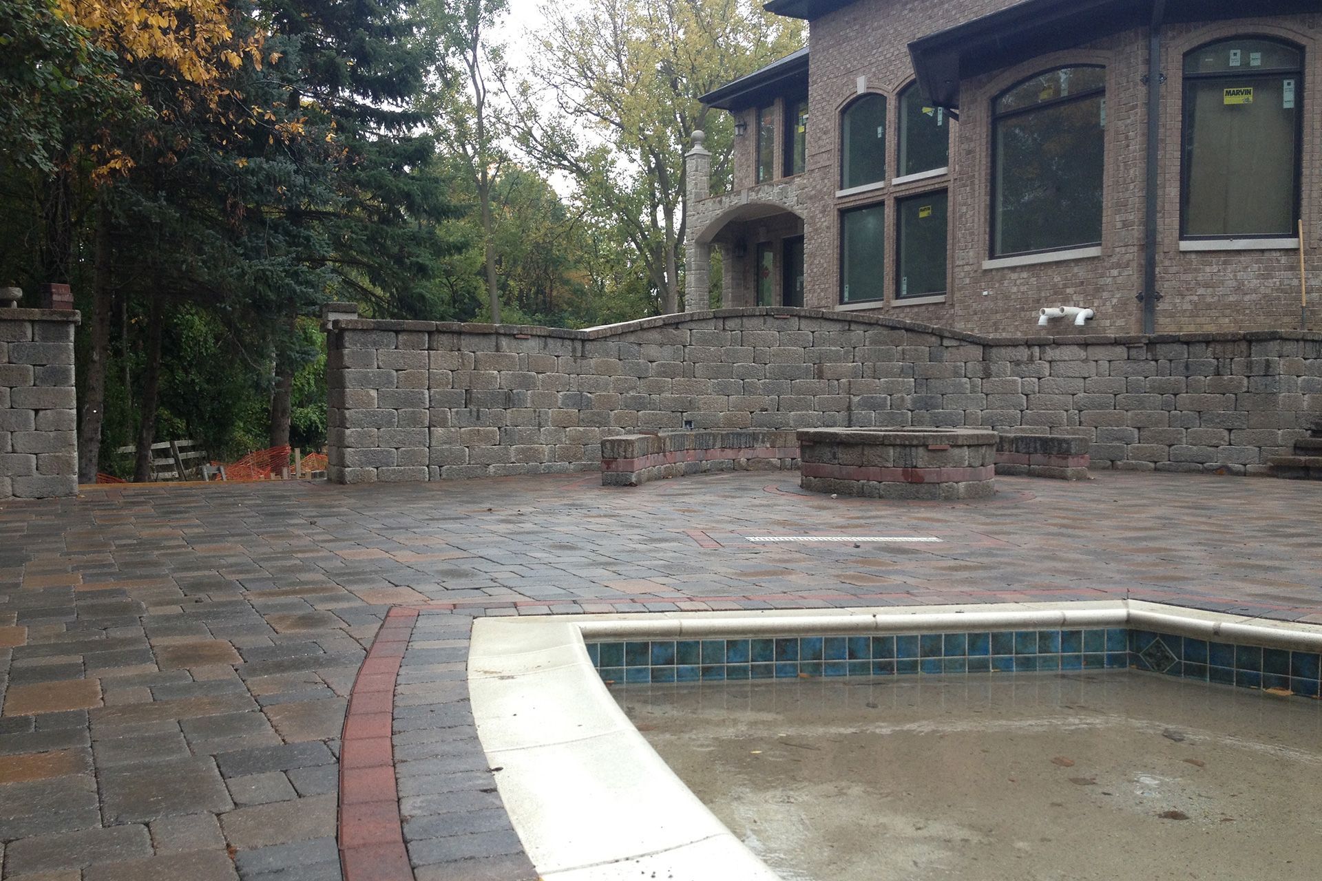 A large brick house with a pool in front of it