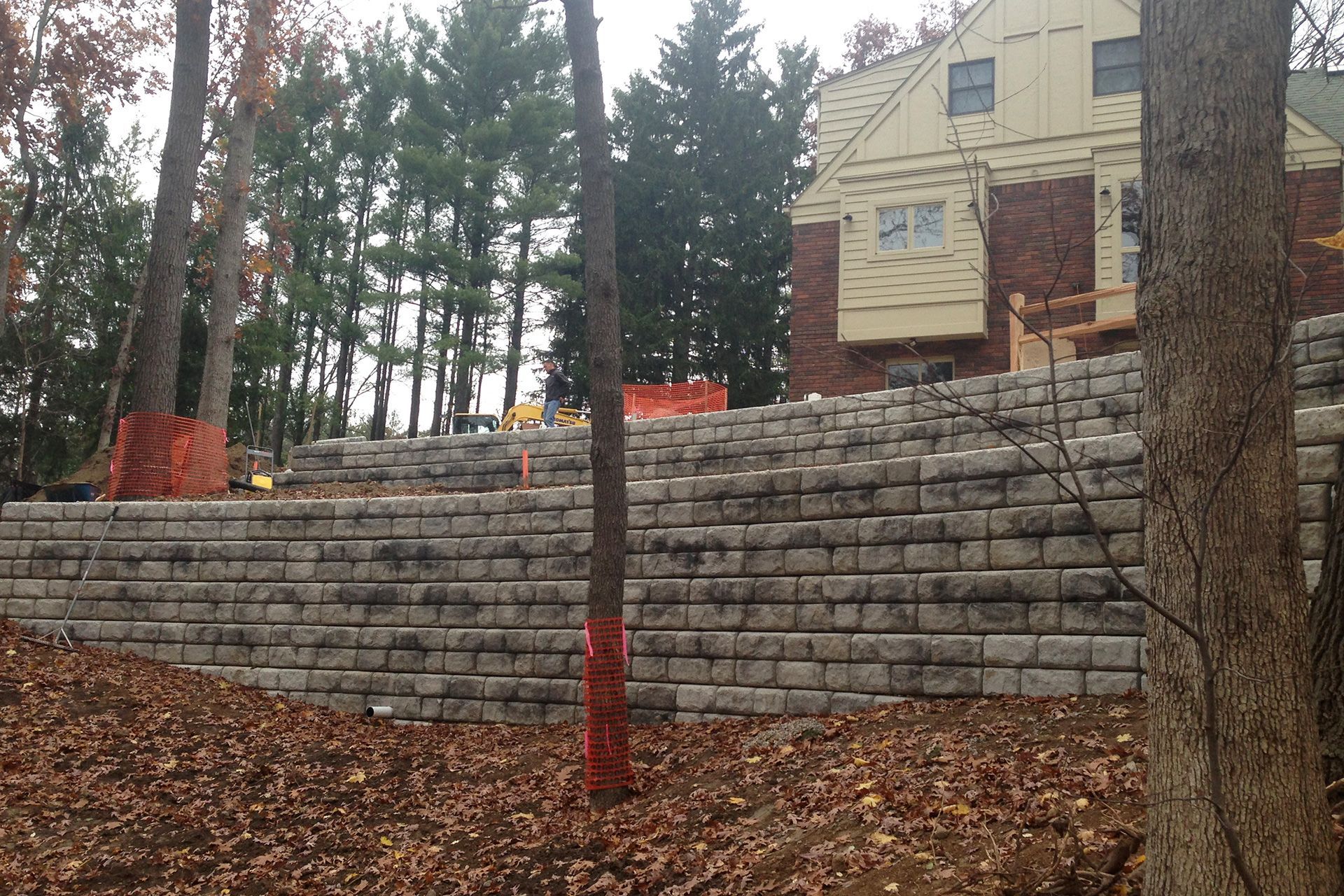 A brick wall is being built in front of a house