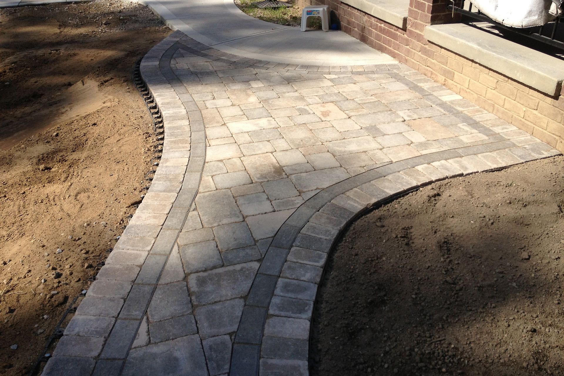 A brick walkway is being built in front of a brick building