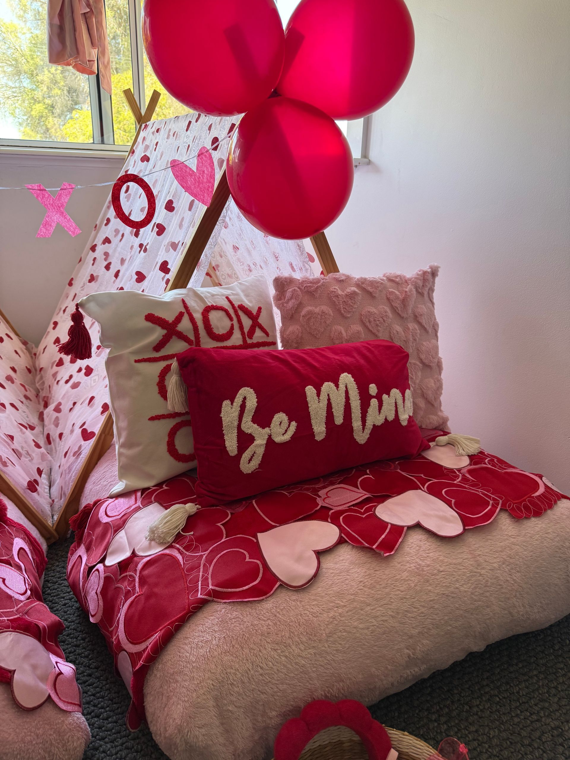 Valentine’s Day display with red balloons, pink pillows, and “Be Mine” heart pillows on a couch — Sweet Parties & Braids in Tatton, NSW