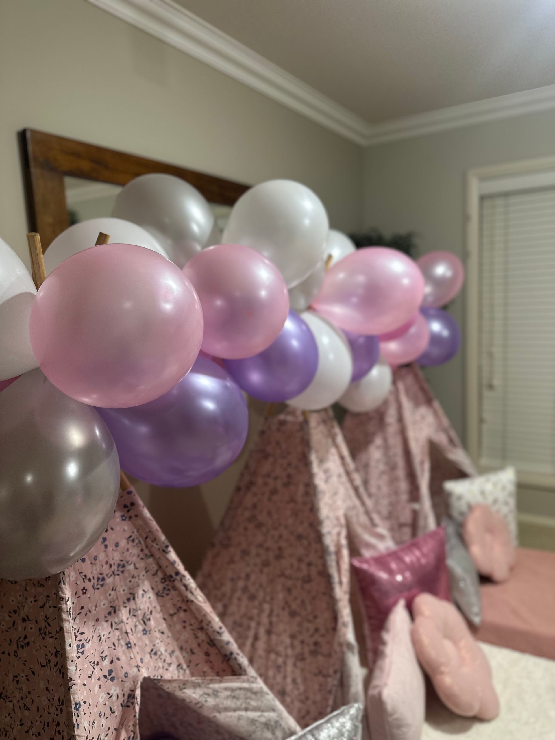 Mermaid birthday party setup with pink flowers, sign, gifts, and a tray on grass — Sweet Parties & Braids in Tatton, NSW