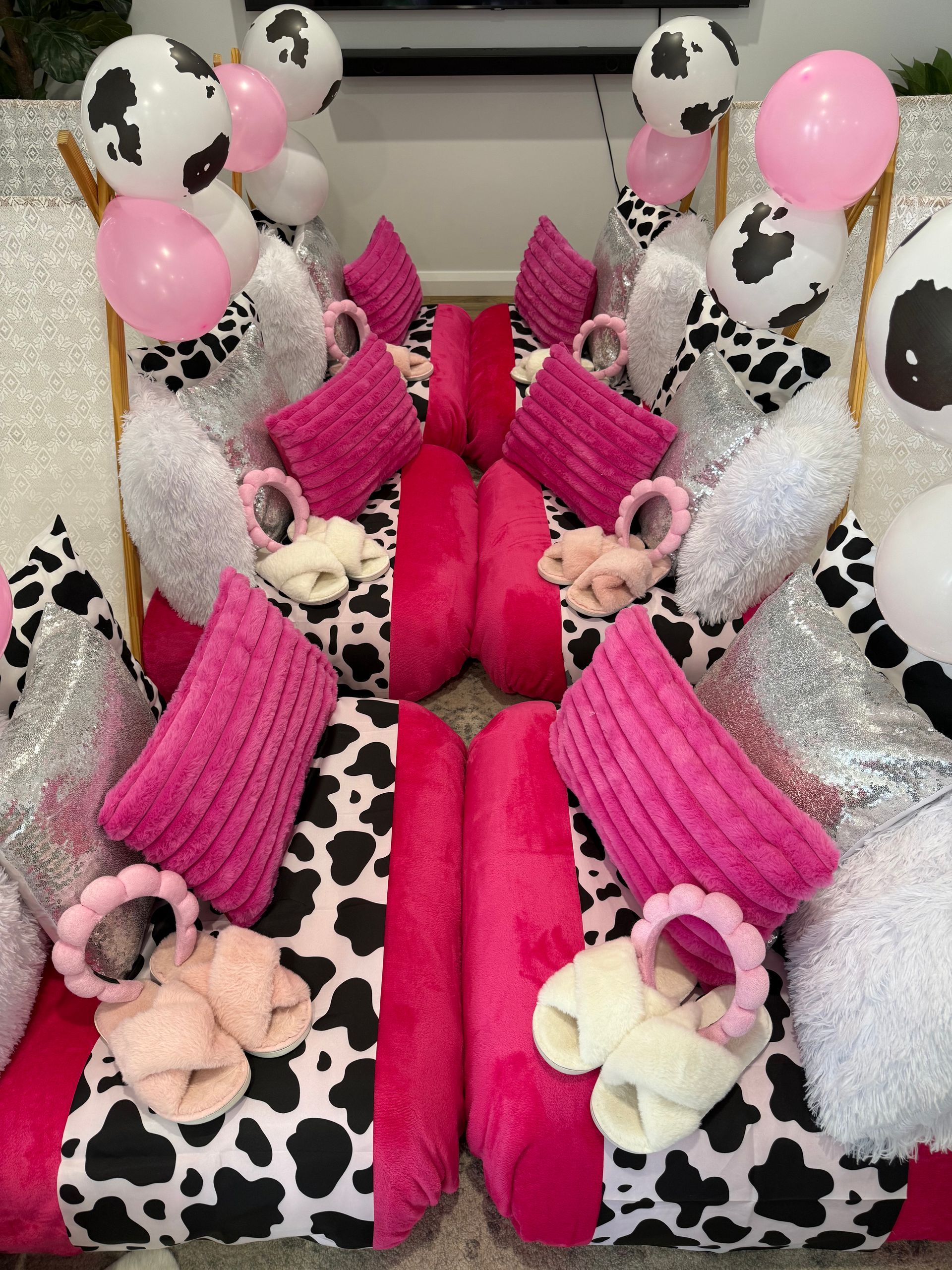 Pink-and-black cow-print toy display with balloons, bows, and small plush bears arranged symmetrically — Sweet Parties & Braids in Tatton, NSW