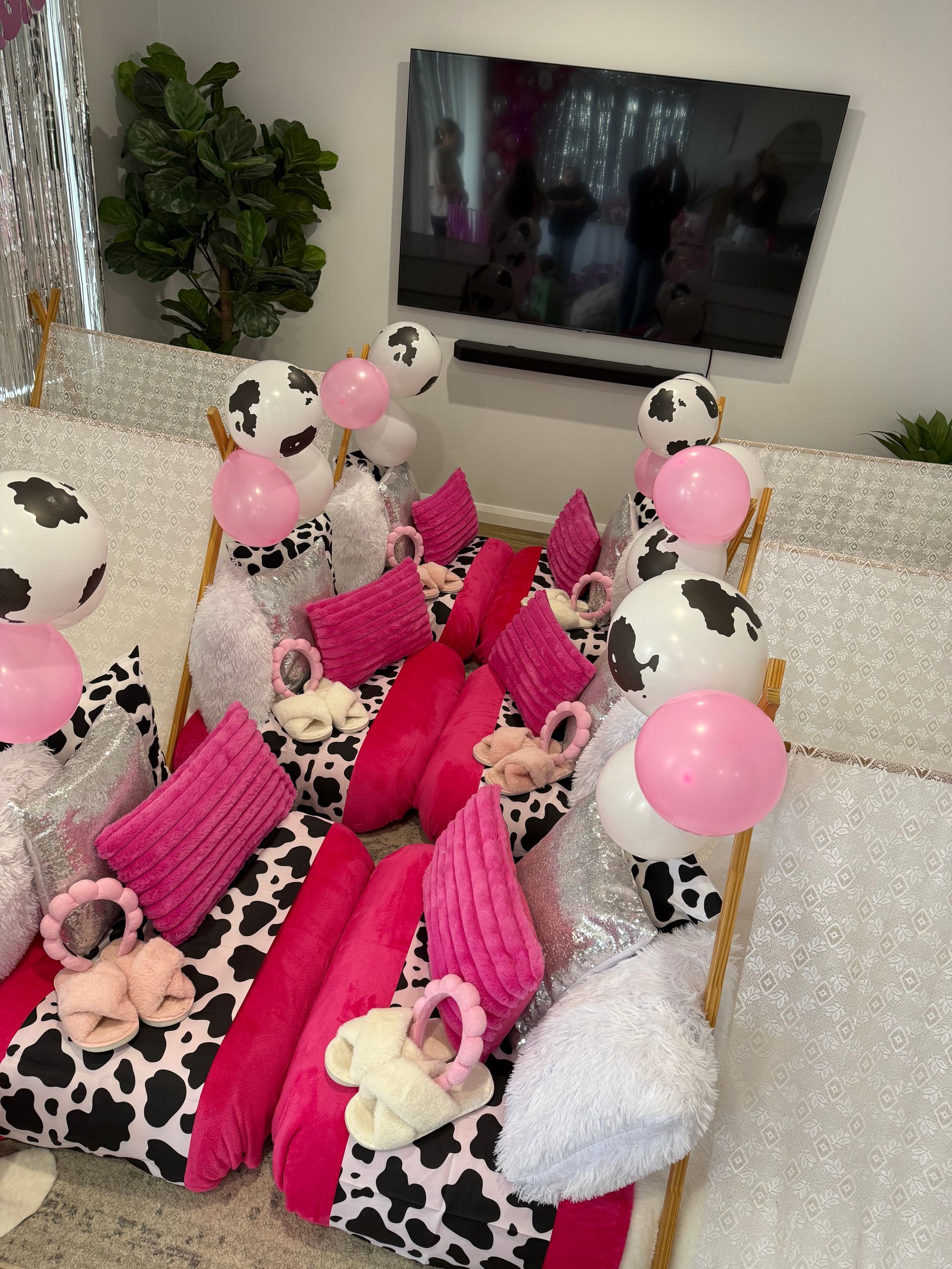 Decorated party table with pink balloons, cow-print boxes, and stuffed animals in a bright room — Sweet Parties & Braids in Tatton, NSW