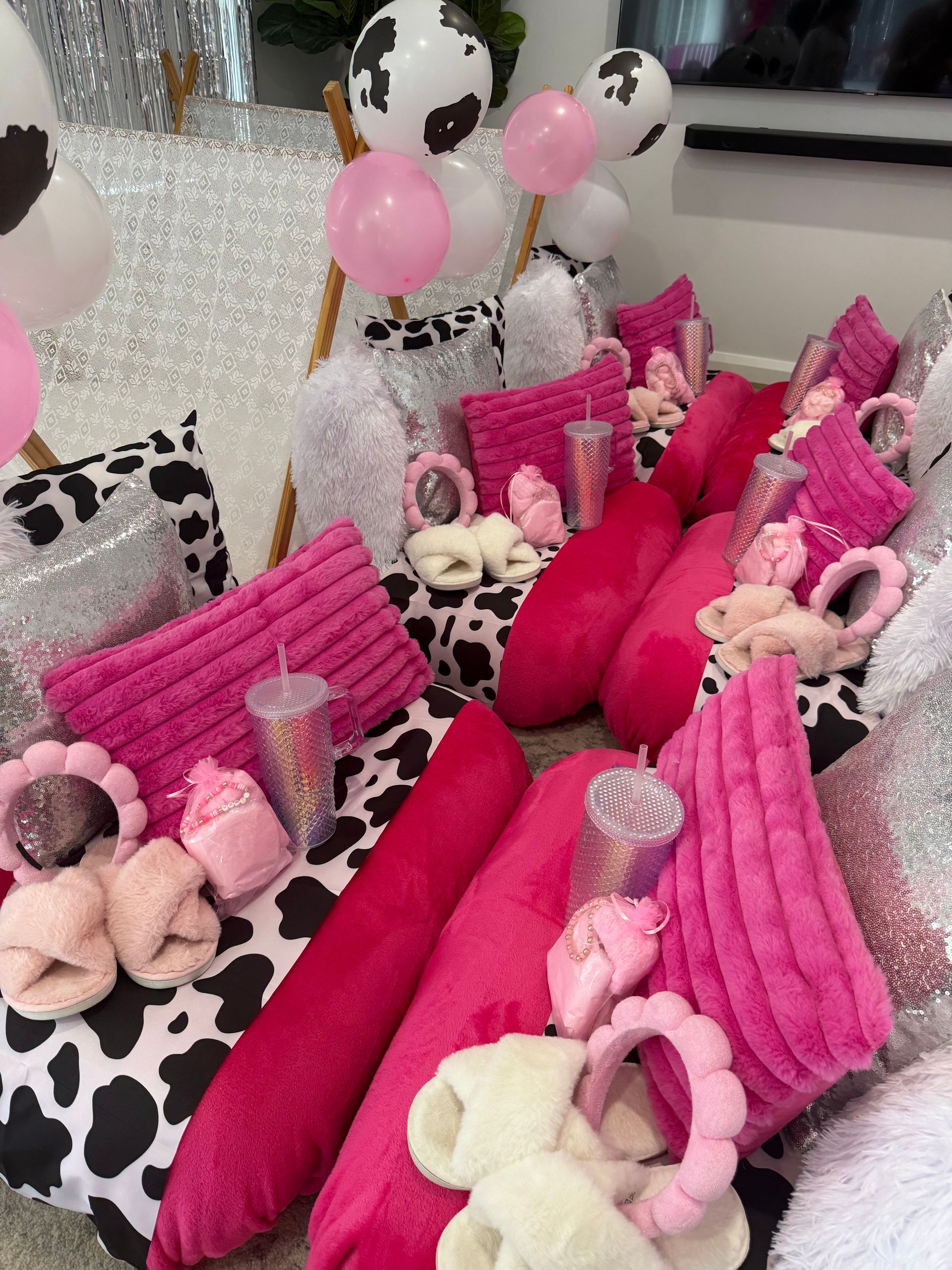 Knitted baby doll display with pink blankets, cow-print pillows, and balloons in a cozy room — Sweet Parties & Braids in Tatton, NSW