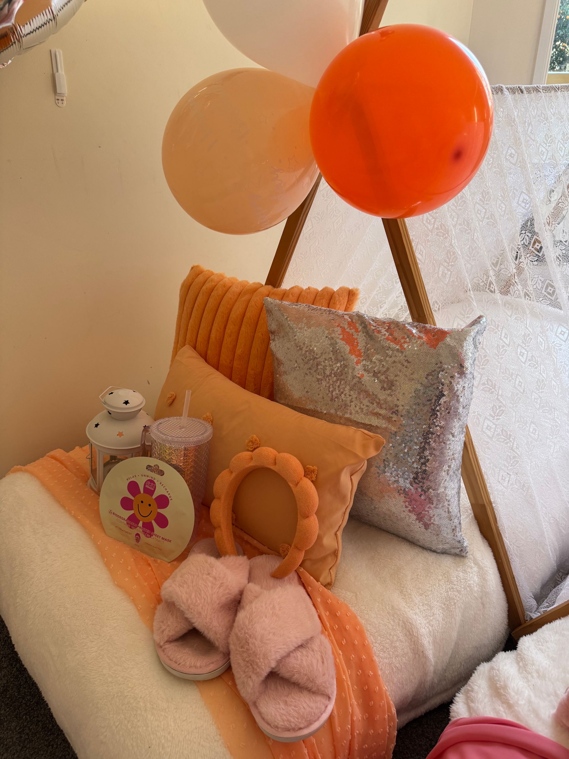 Cozy chair with pastel pillows, balloon decorations, plush toys, and soft orange accents in a nursery-like corner — Sweet Parties & Braids in Tatton, NSW