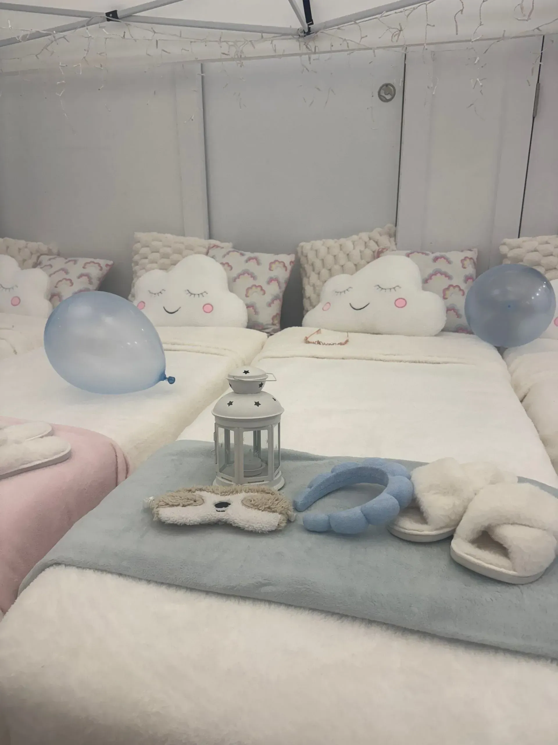 A Cozy Bed With Pillows, Blue Balloons, and Folded Blankets — Sweet Parties & Braids in Tatton, NSW