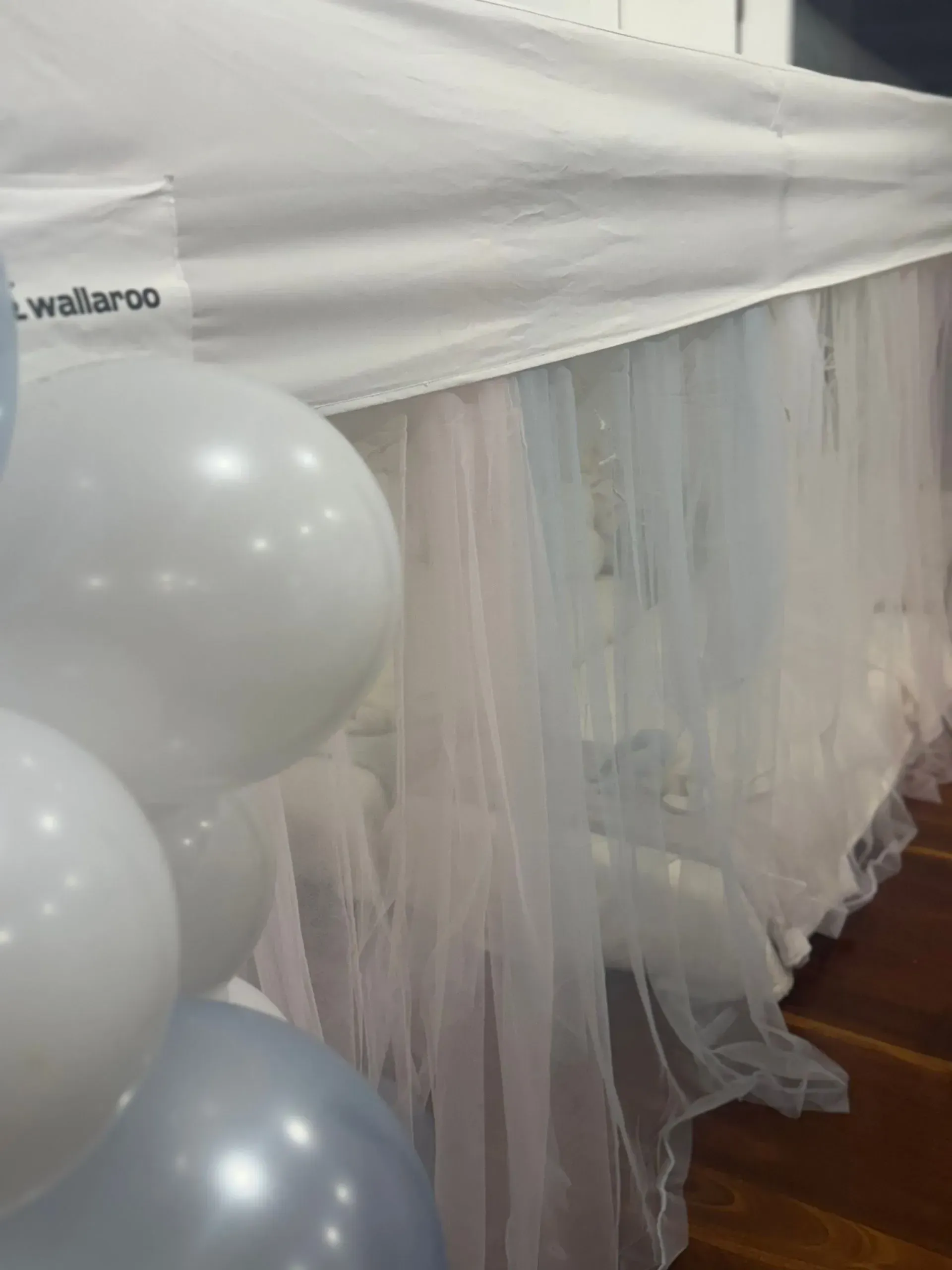 White Draped Table With Sheer Fabric and White, Silver, and Blue Balloons — Sweet Parties & Braids in Tatton, NSW