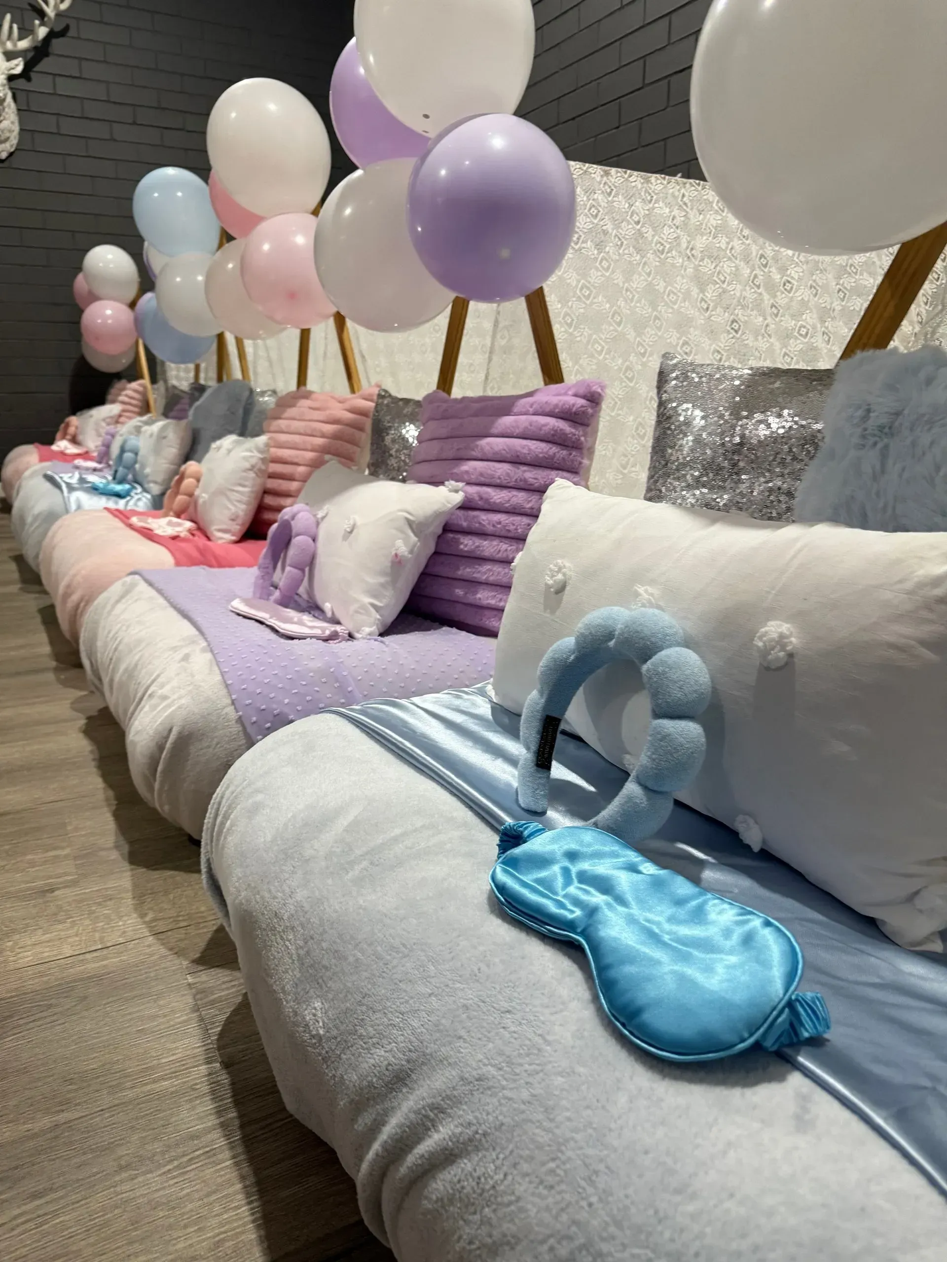 Pastel Balloons and Pillows on a Row of Decorated Lounge Seats — Sweet Parties & Braids in Tatton, NSW